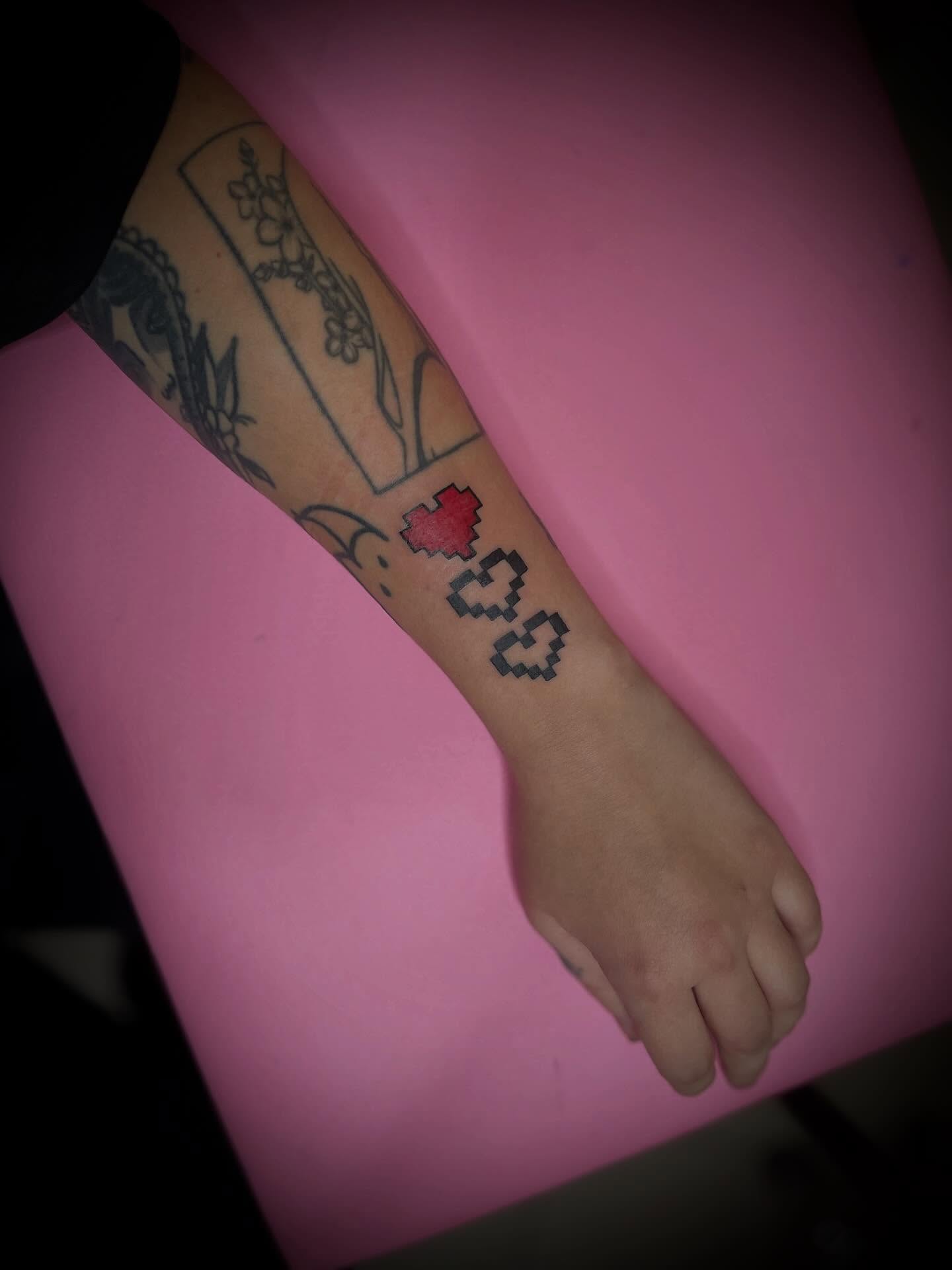 Pixelated heart and numbers dotwork tattoo on the forearm by lu ๐