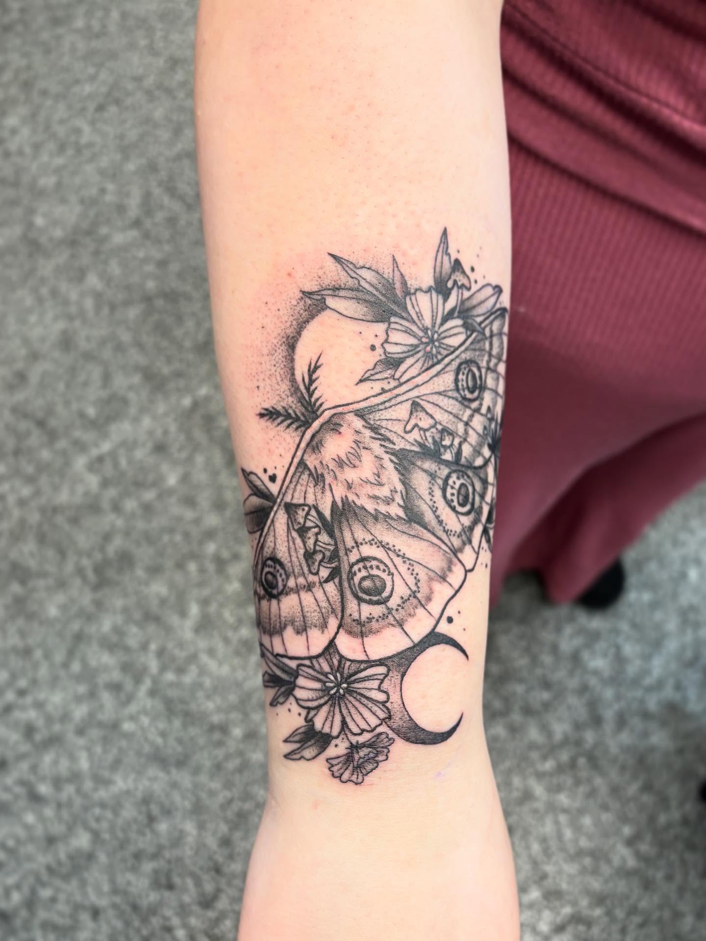 Moth and flowers dotwork tattoo on the forearm by Jayda Shell