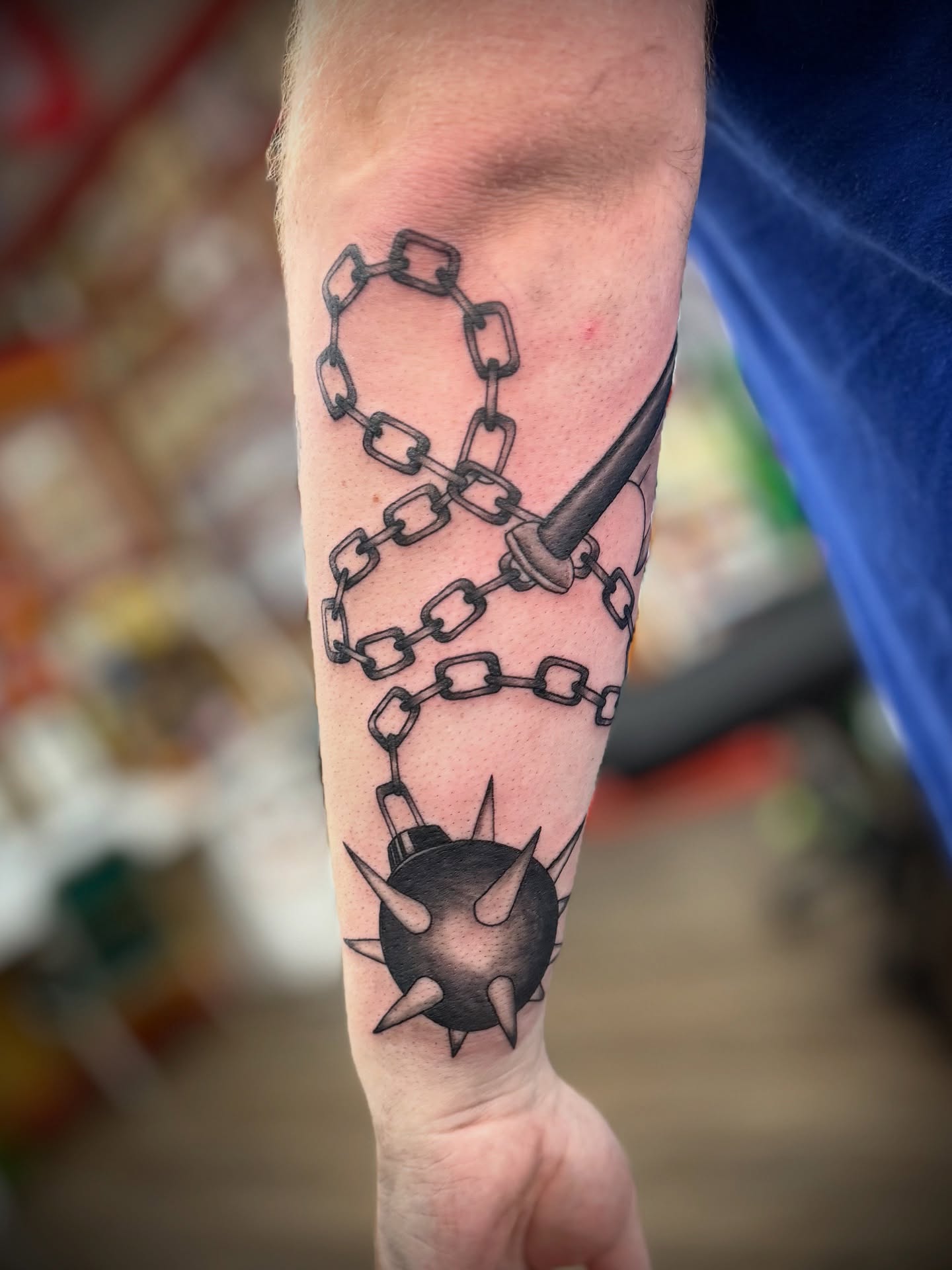 Chains and spiked ball black and grey tattoo on the forearm by Justin Bianchini - New Orleans Tattoo Artist