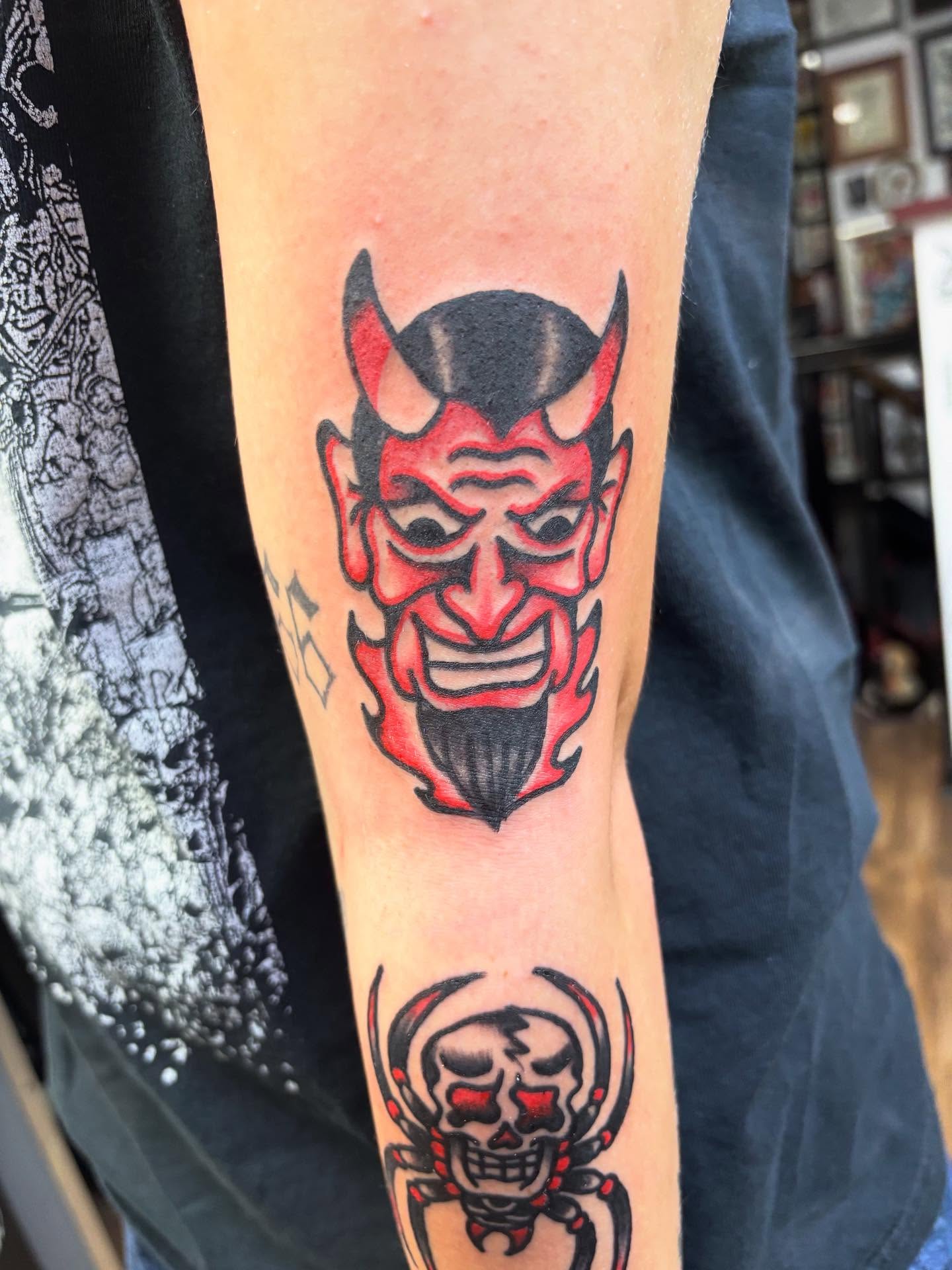 Demon face American traditional tattoo on the forearm by Dave