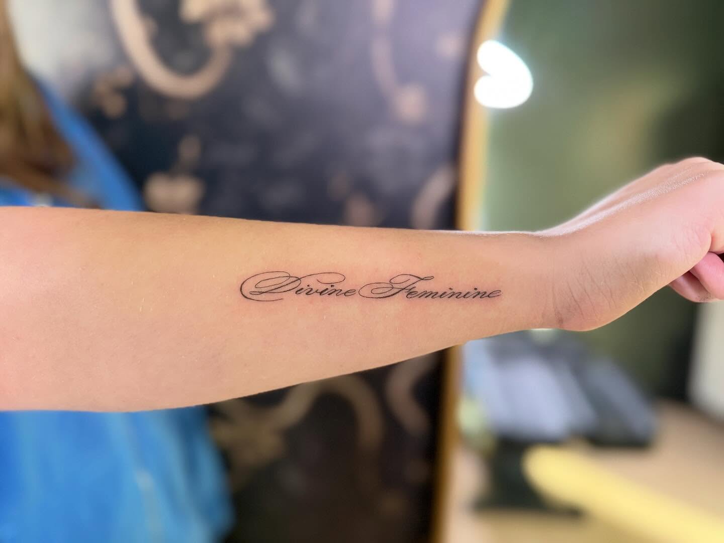 Divine Feminine lettering script tattoo on the forearm by Fineline Tattoos π€ Hailey L.