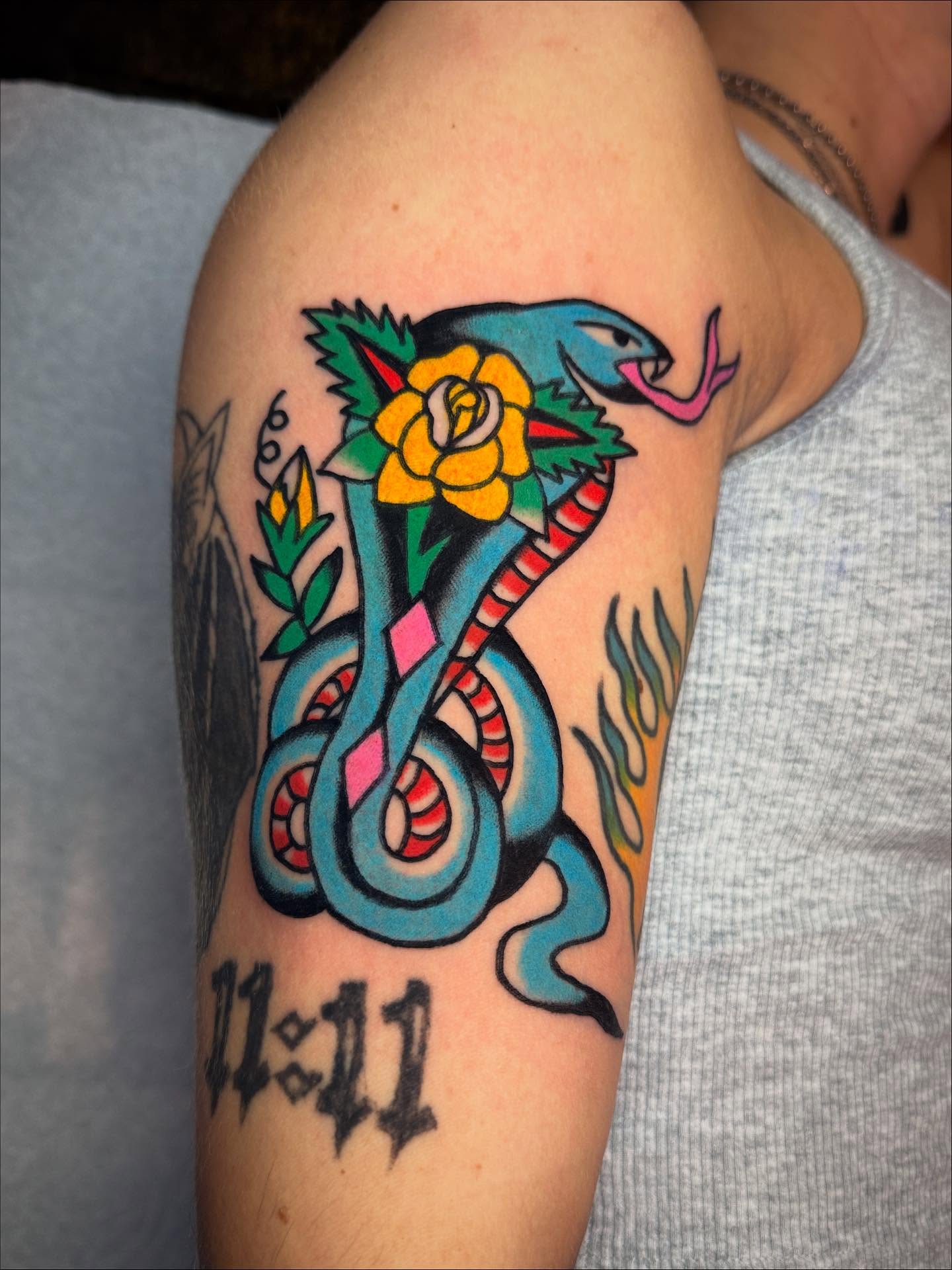 Snake and rose American traditional tattoo on the forearm by Britt Kuechenmeister, Culver City, California
