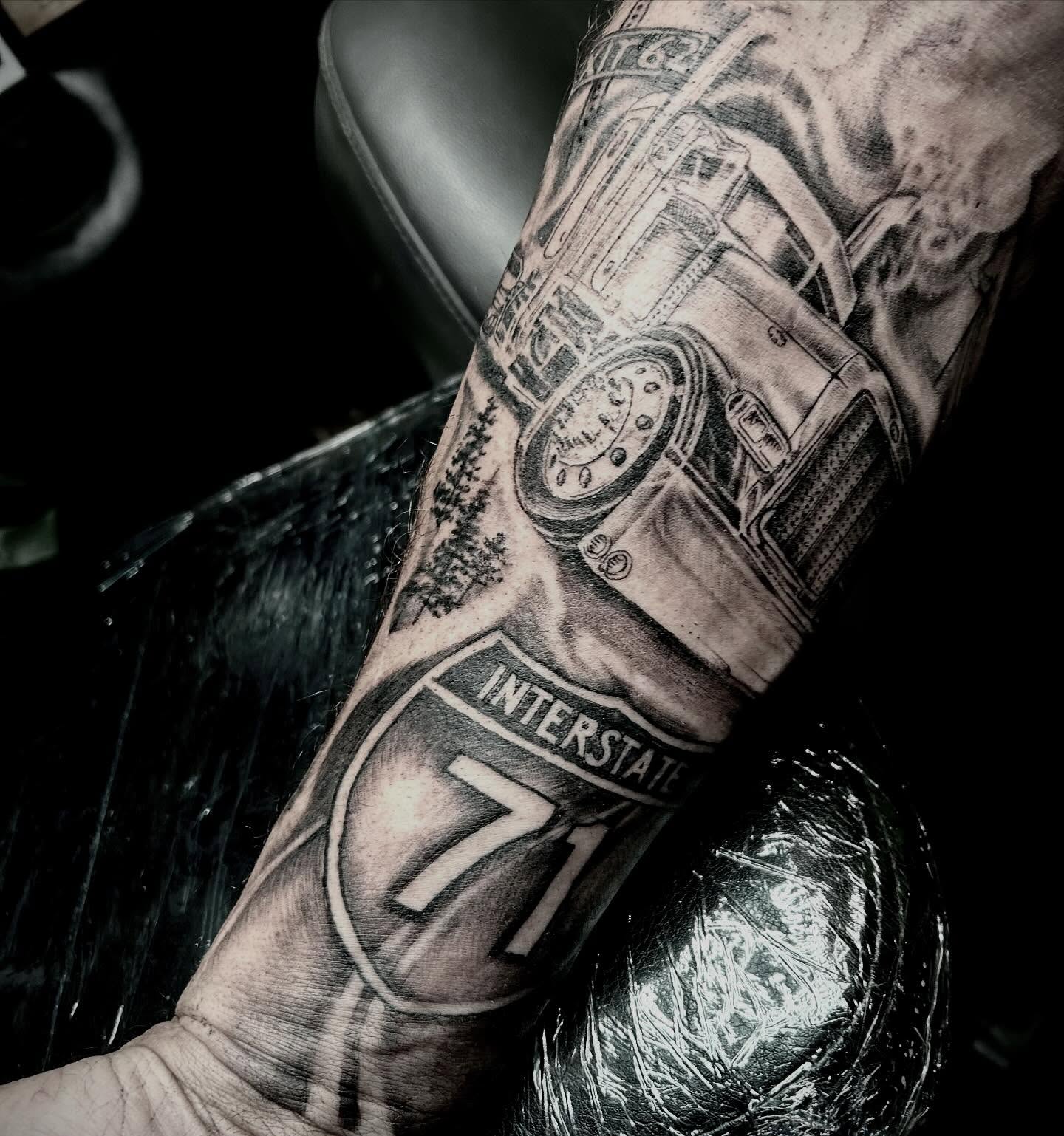 Truck and interstate sign realism tattoo on the forearm by Matthew Clanin