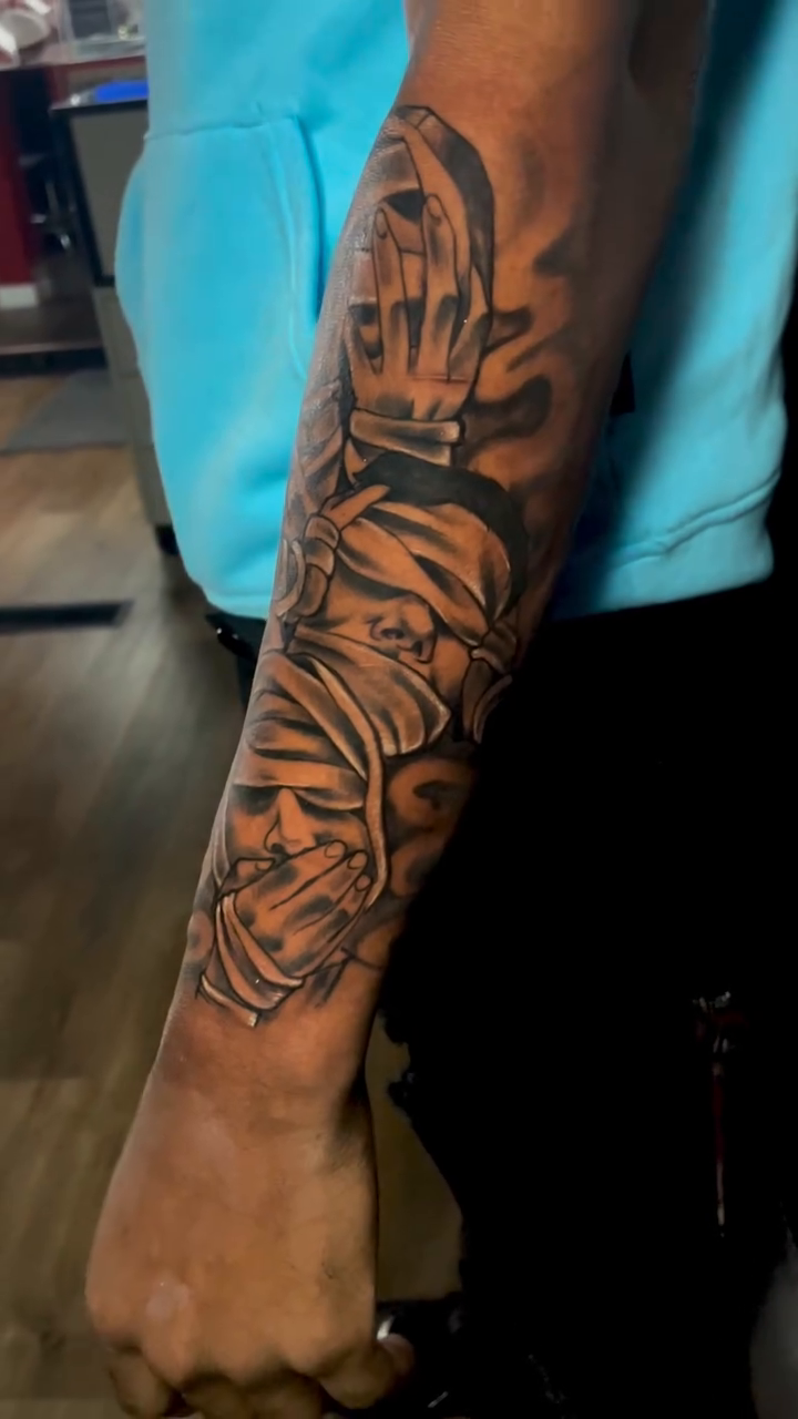 Praying hands and faces realism tattoo on the forearm by Inkman Parson