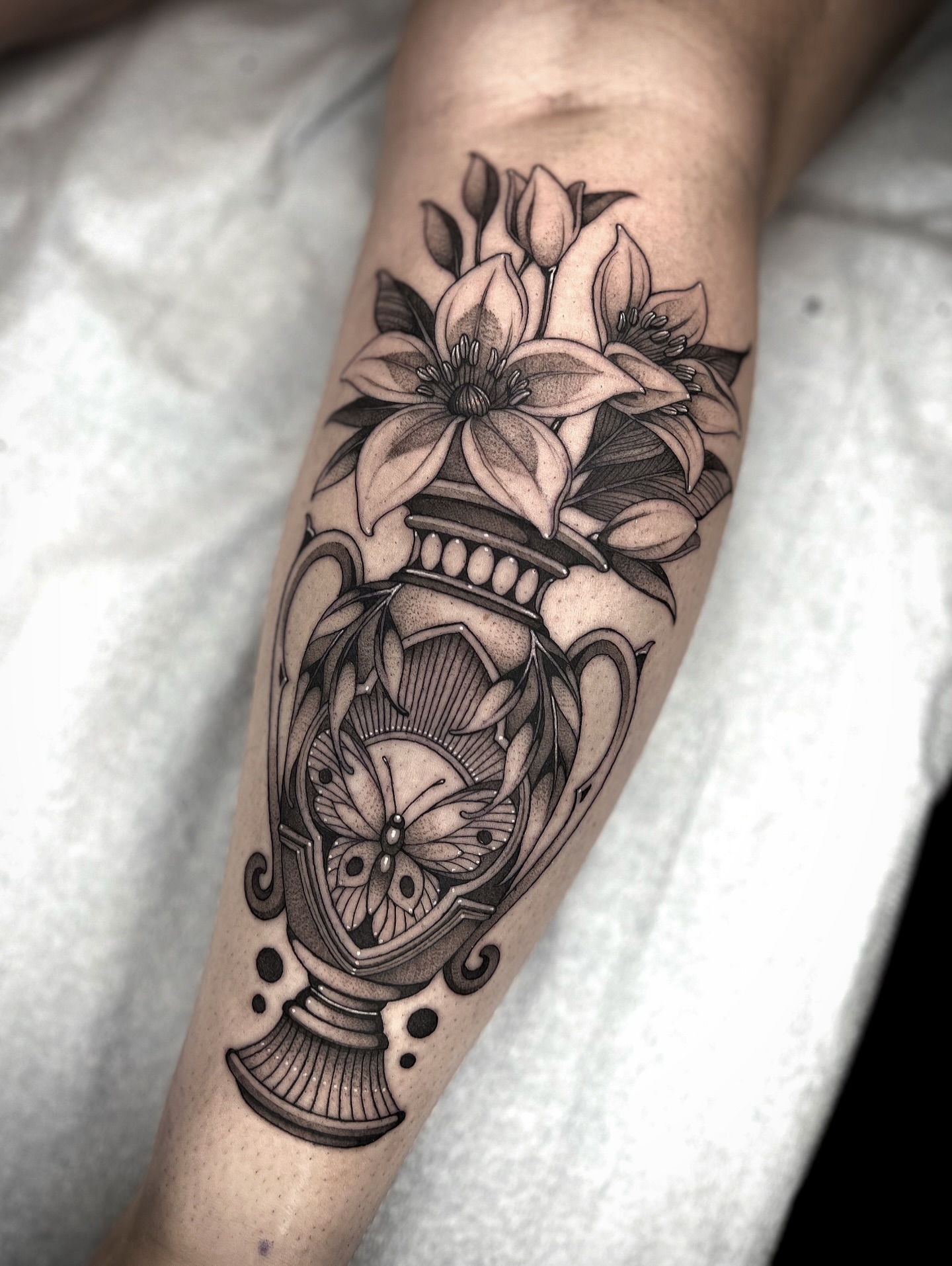 Flowers and vase black and grey tattoo on the forearm by Kaysee Shuster
