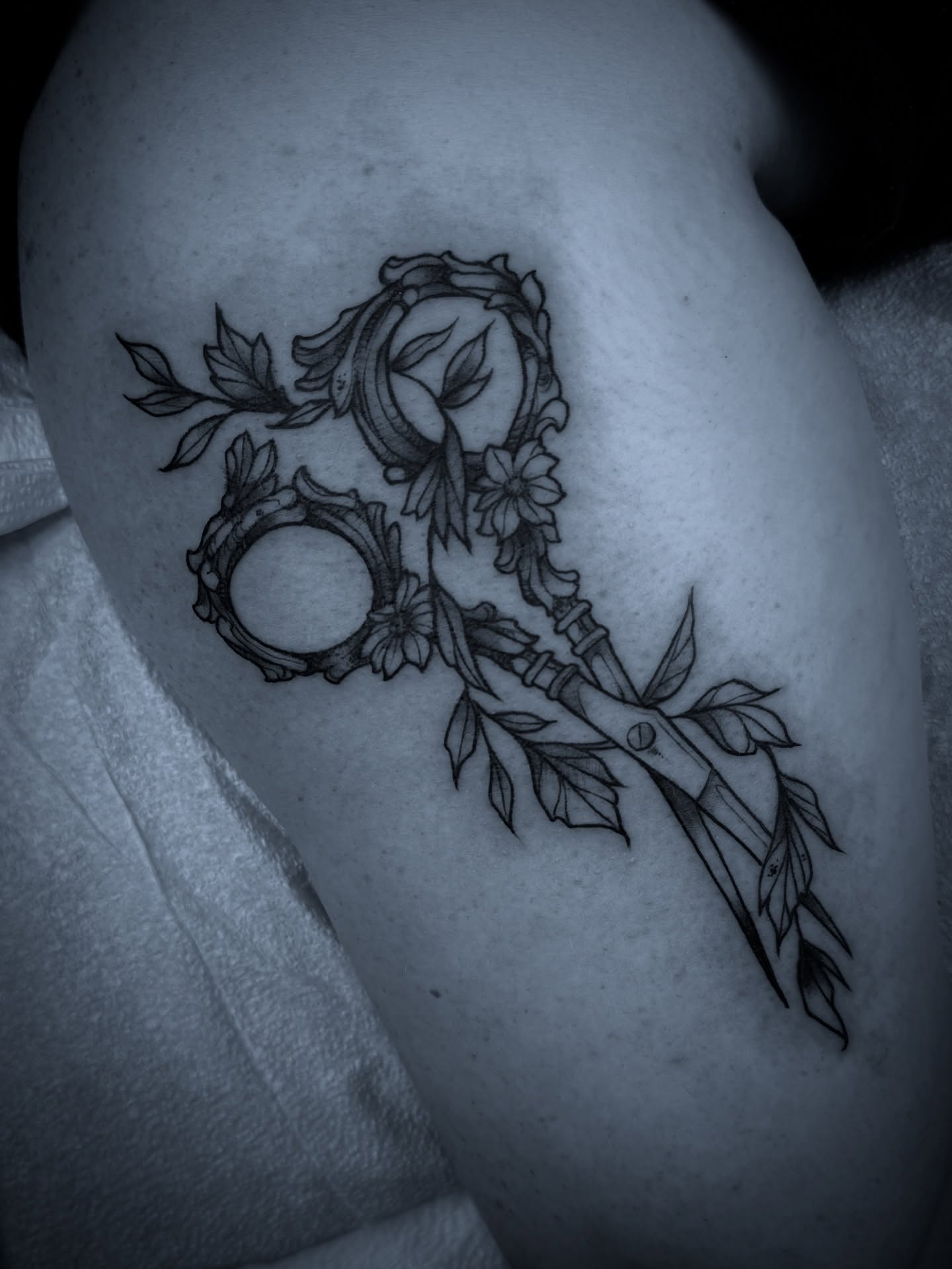 Key with floral elements black and grey tattoo on the shoulder by Michael Langdale