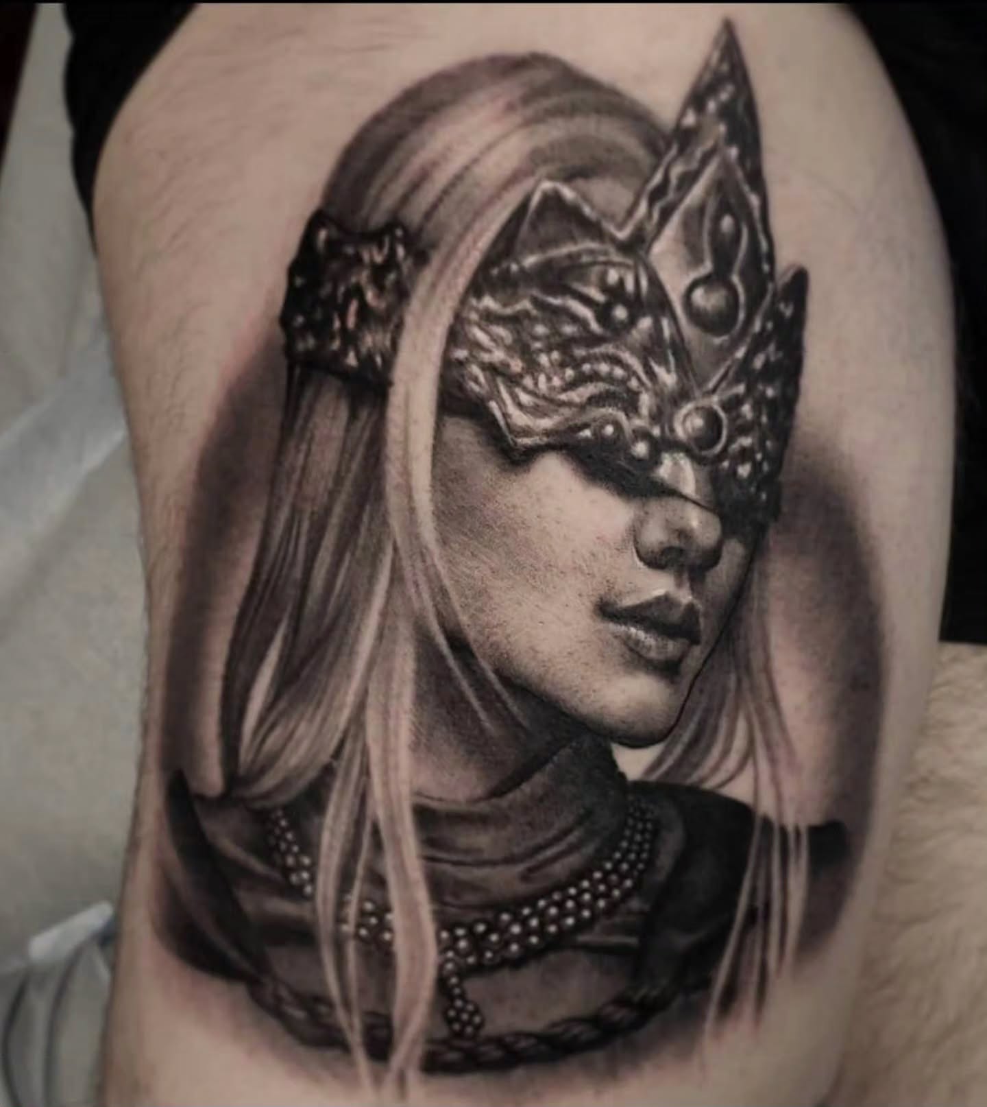 Woman wearing mask realism tattoo on the thigh by Dani Ryan