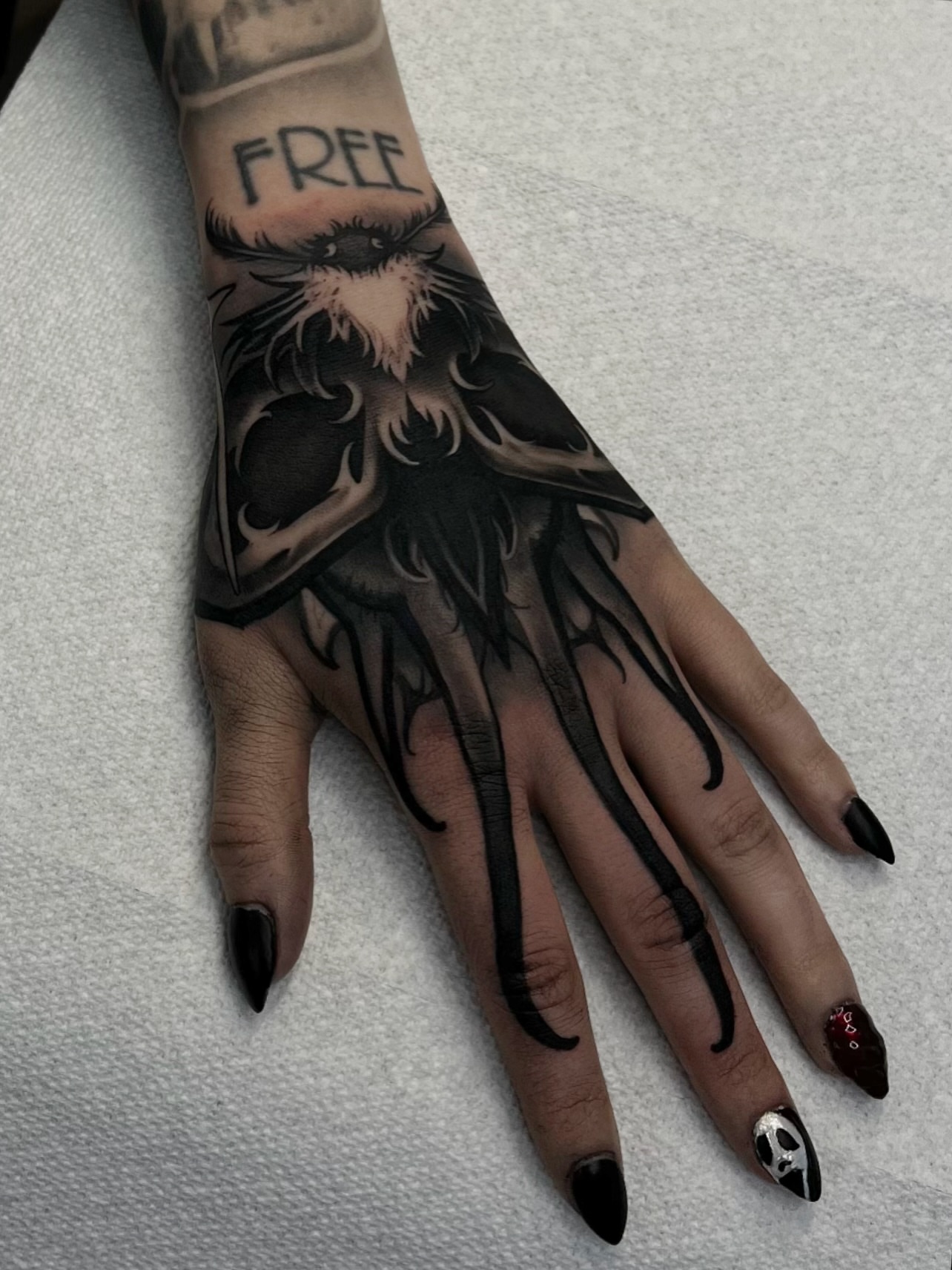 Owl black and grey tattoo on the hand by Madison Ast Tattoo