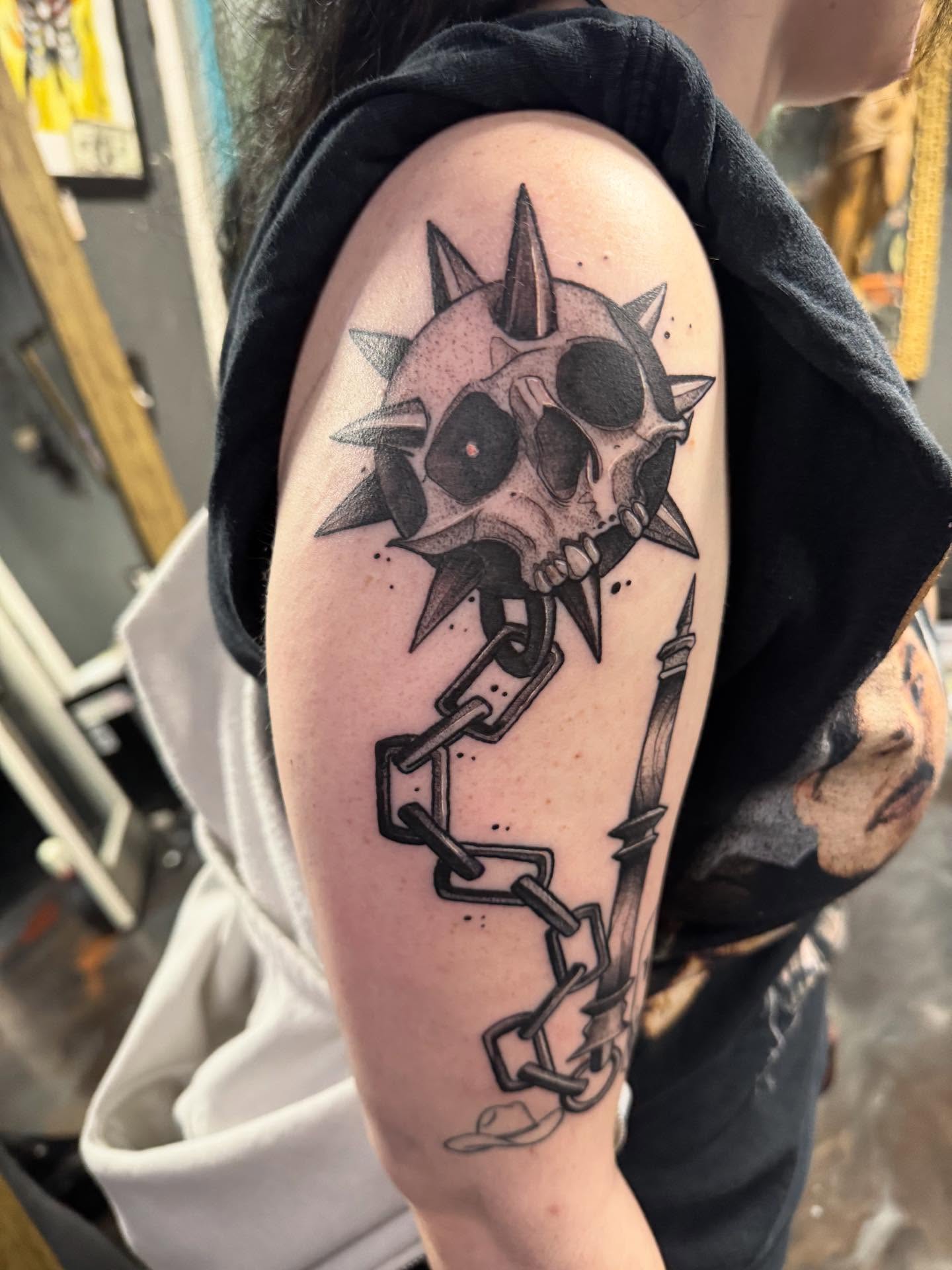 Spiked skull with chain black and grey tattoo on the shoulder by Kyle Haitch, Las Vegas, Nevada