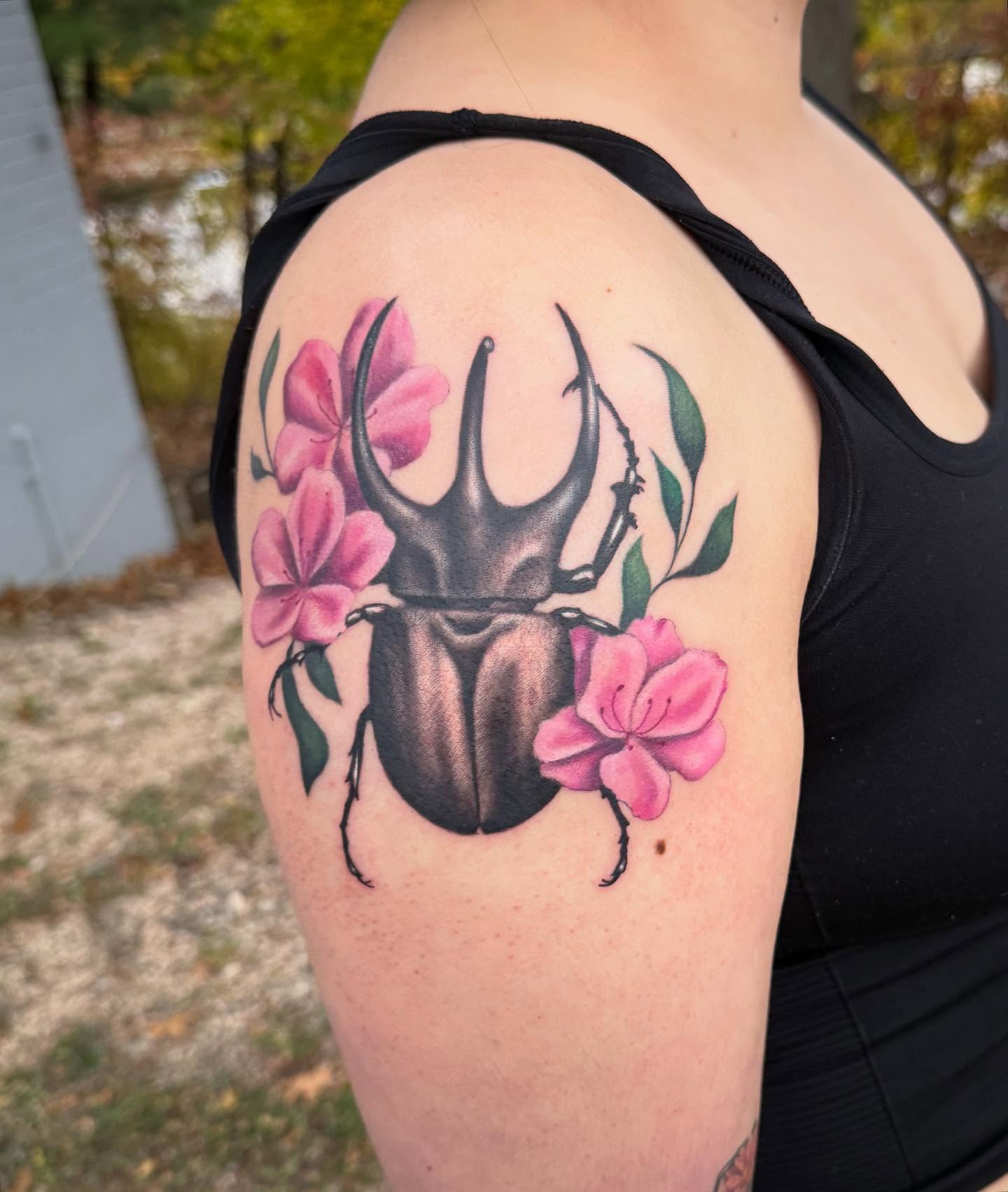 Rhinoceros beetle and flowers realism tattoo on the shoulder by Alexis Monkiewicz