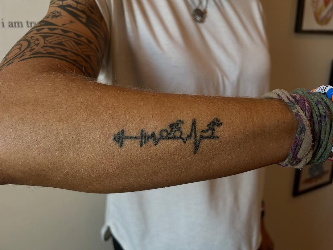 Heartbeat with barbell and runner lettering tattoo on the forearm by Emma D