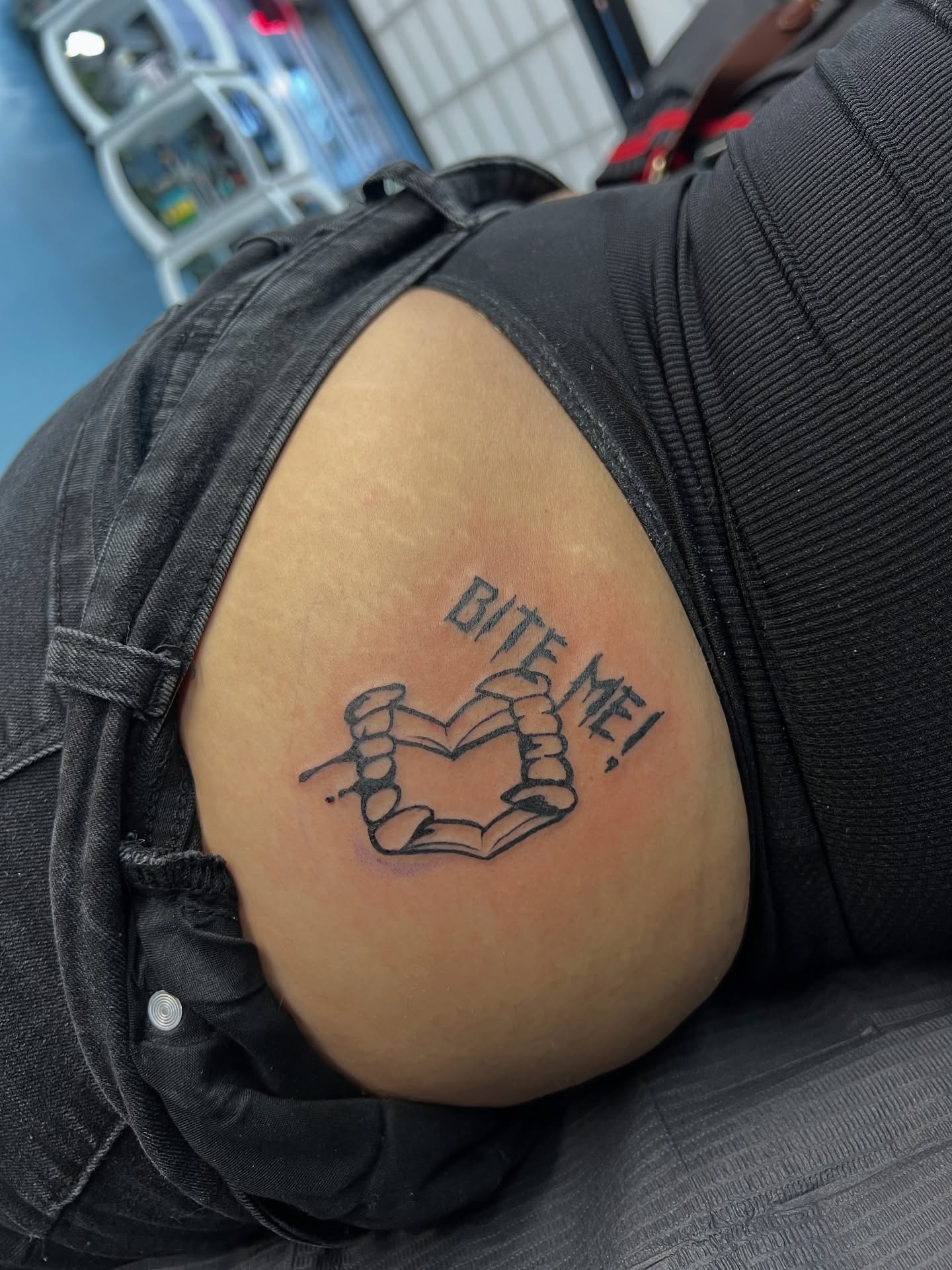 Book and hands black and grey tattoo on the thigh by Tattoo Artist