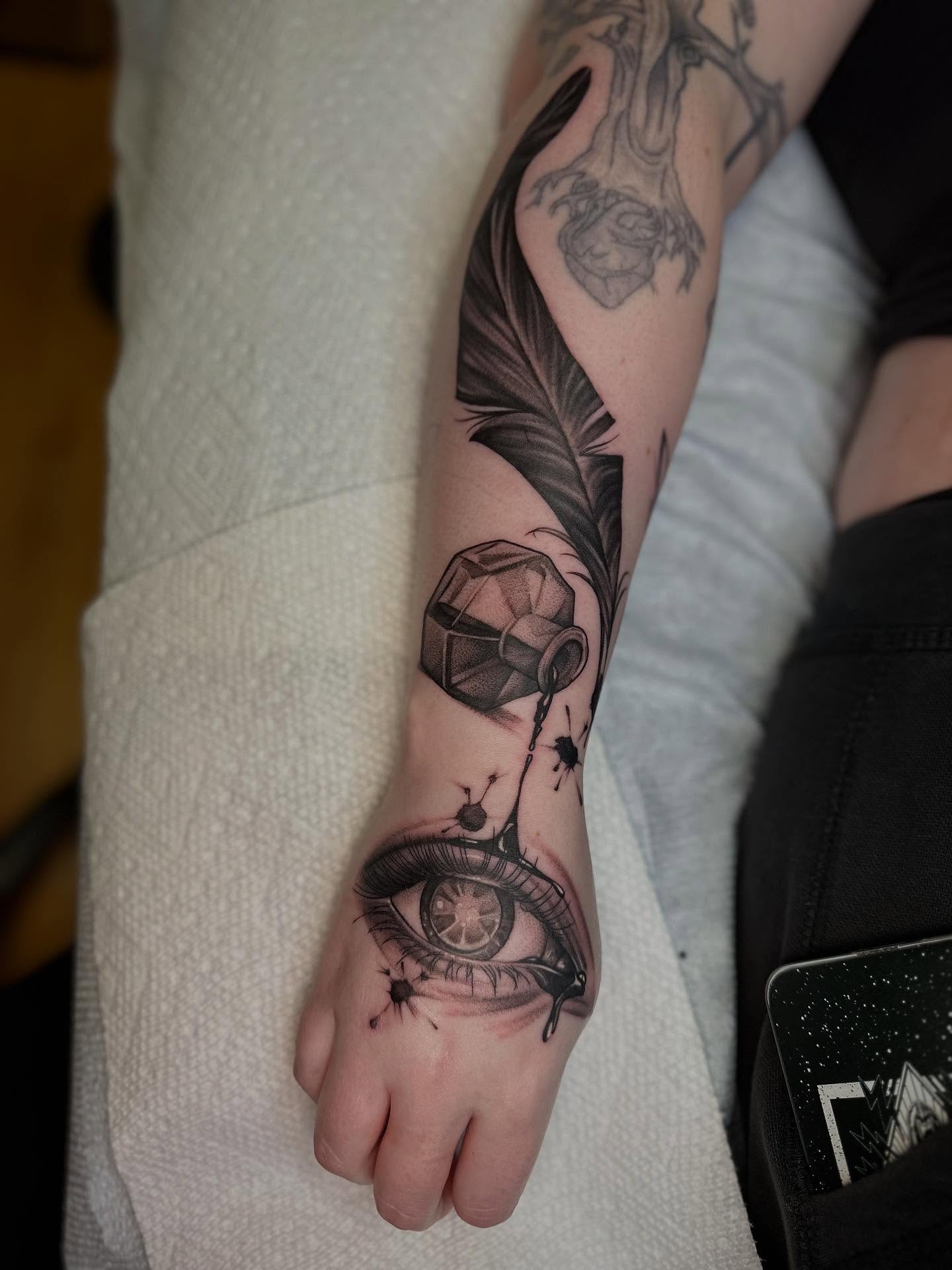 Eye and feather realism tattoo on the forearm by ๐ฎ Kira Yamanashi