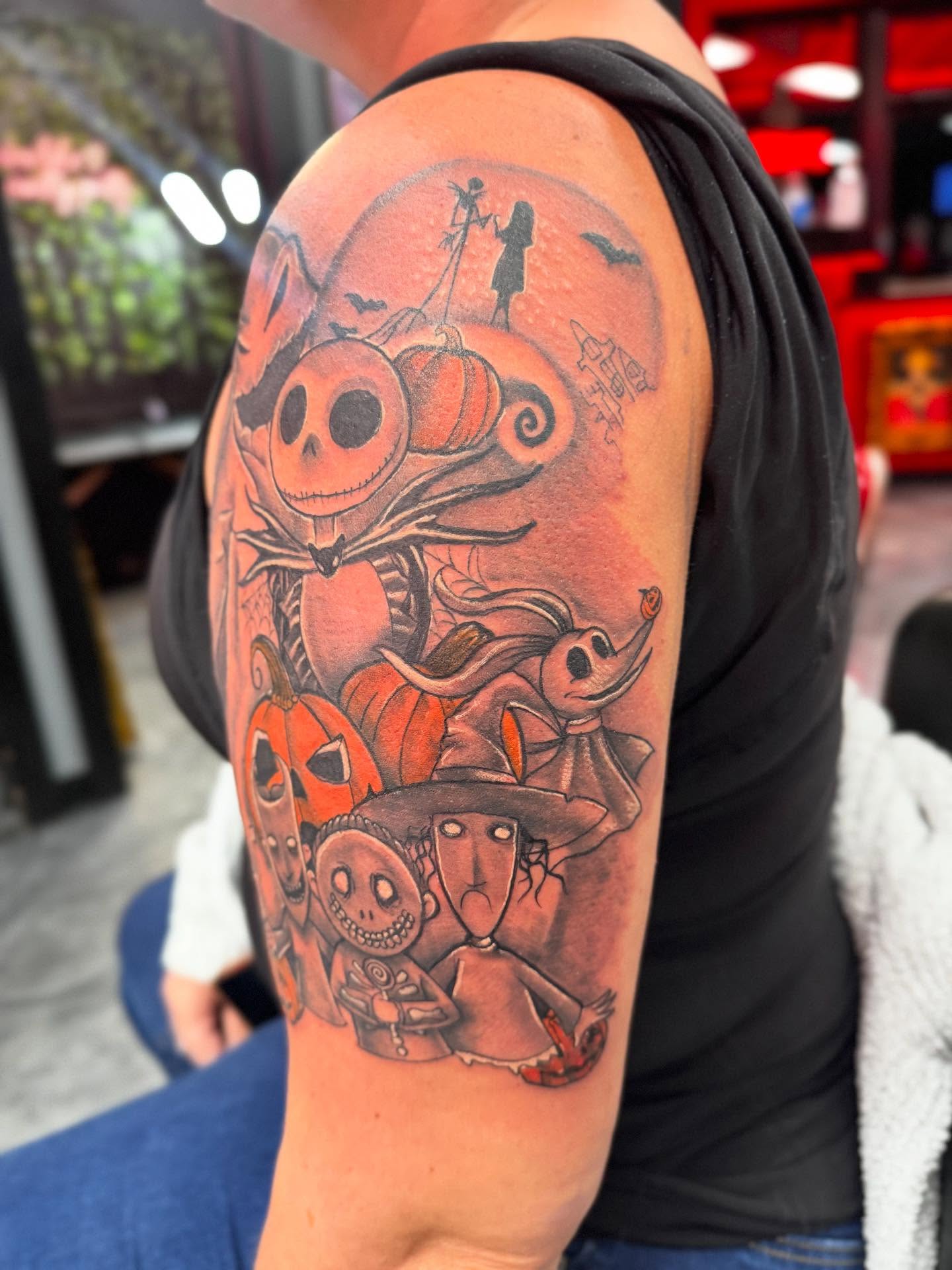 The Nightmare Before Christmas characters dark realism tattoo on the upper arm by Alejandro Zaragoza