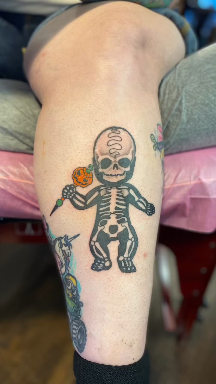 Skeleton holding a pumpkin ignorant tattoo on the forearm by jim collins, Dayton, Ohio