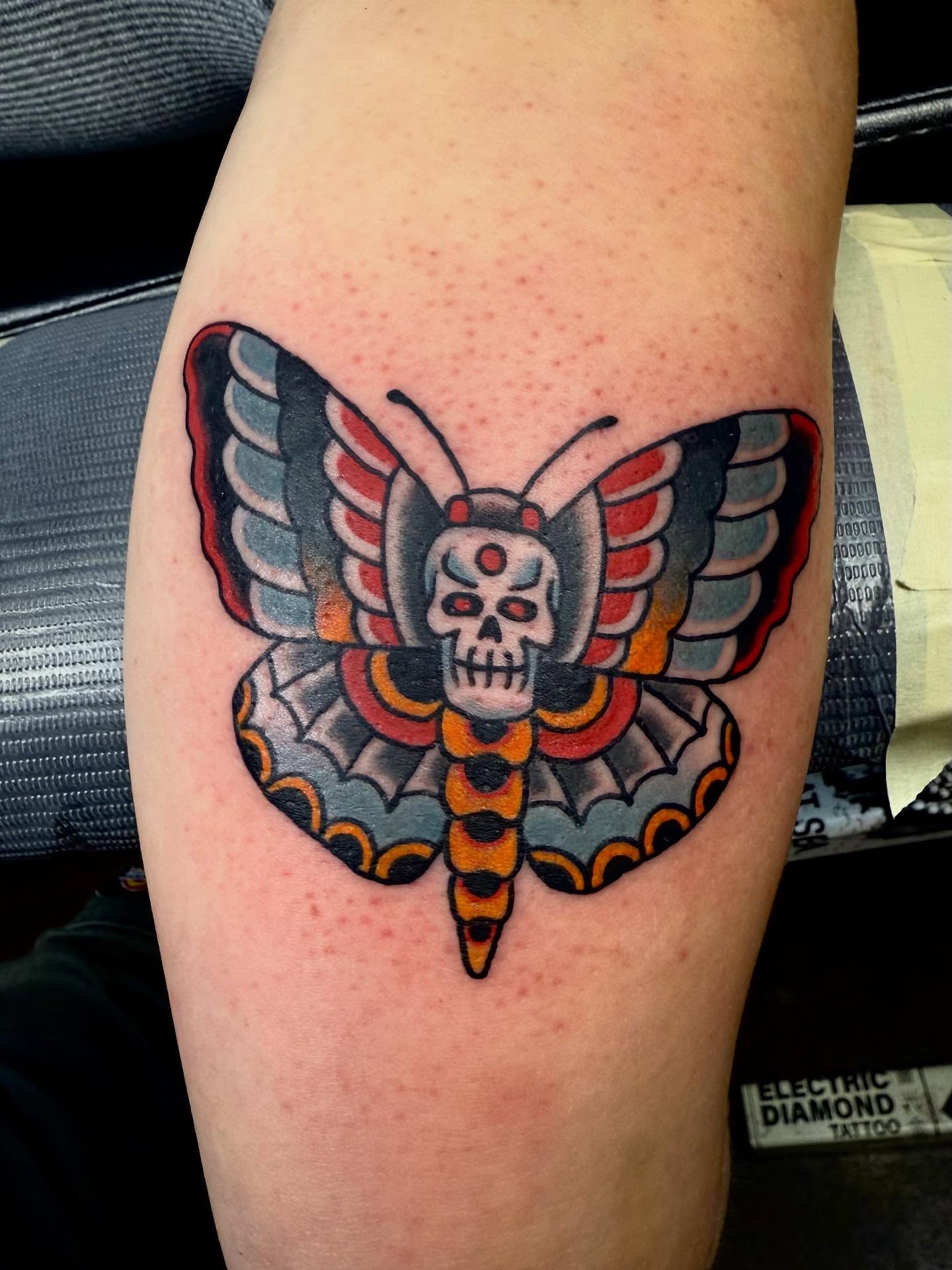 Butterfly skull American traditional tattoo on the thigh by Seth Walker