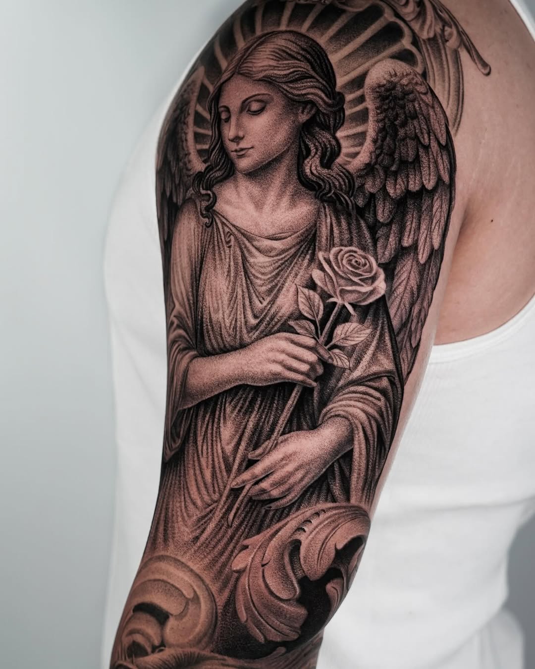 Angel holding a rose realism tattoo on the forearm by Enrique Martinez