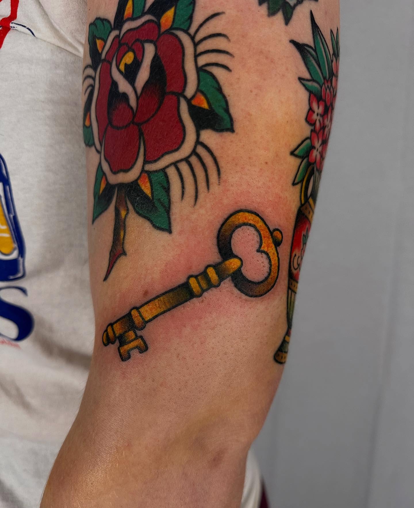 Key and rose American traditional tattoo on the forearm by Hannah Jean