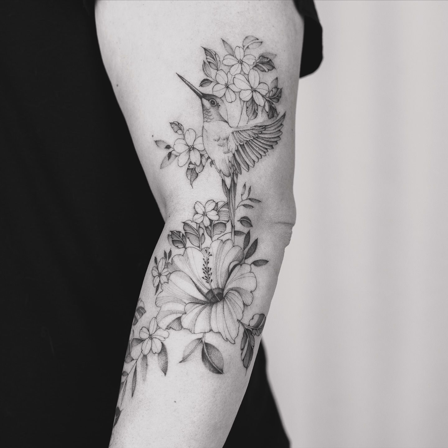 Hummingbird and flowers realism tattoo on the forearm by Leo Gao