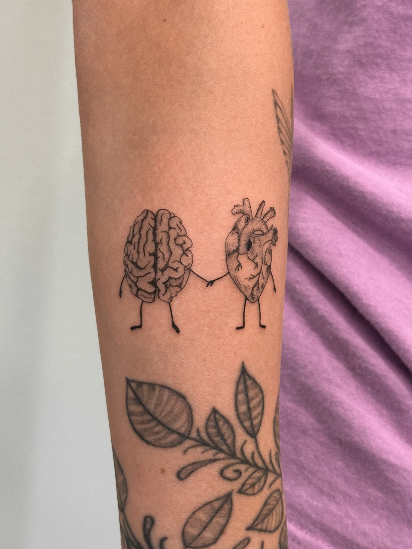 Brain and heart black and grey tattoo on the forearm by Alex