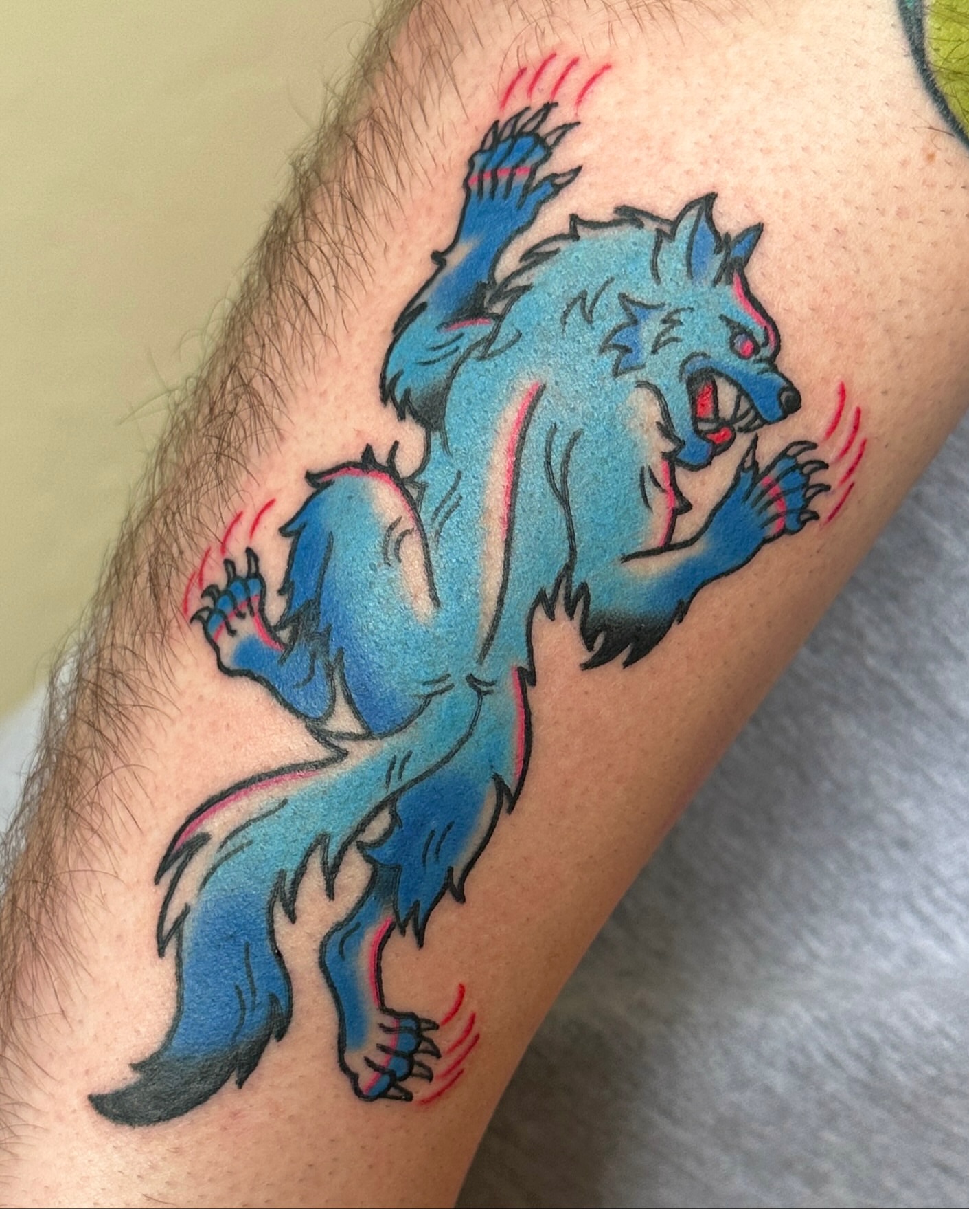 Blue wolf American traditional tattoo on the forearm by Paige Ochoa