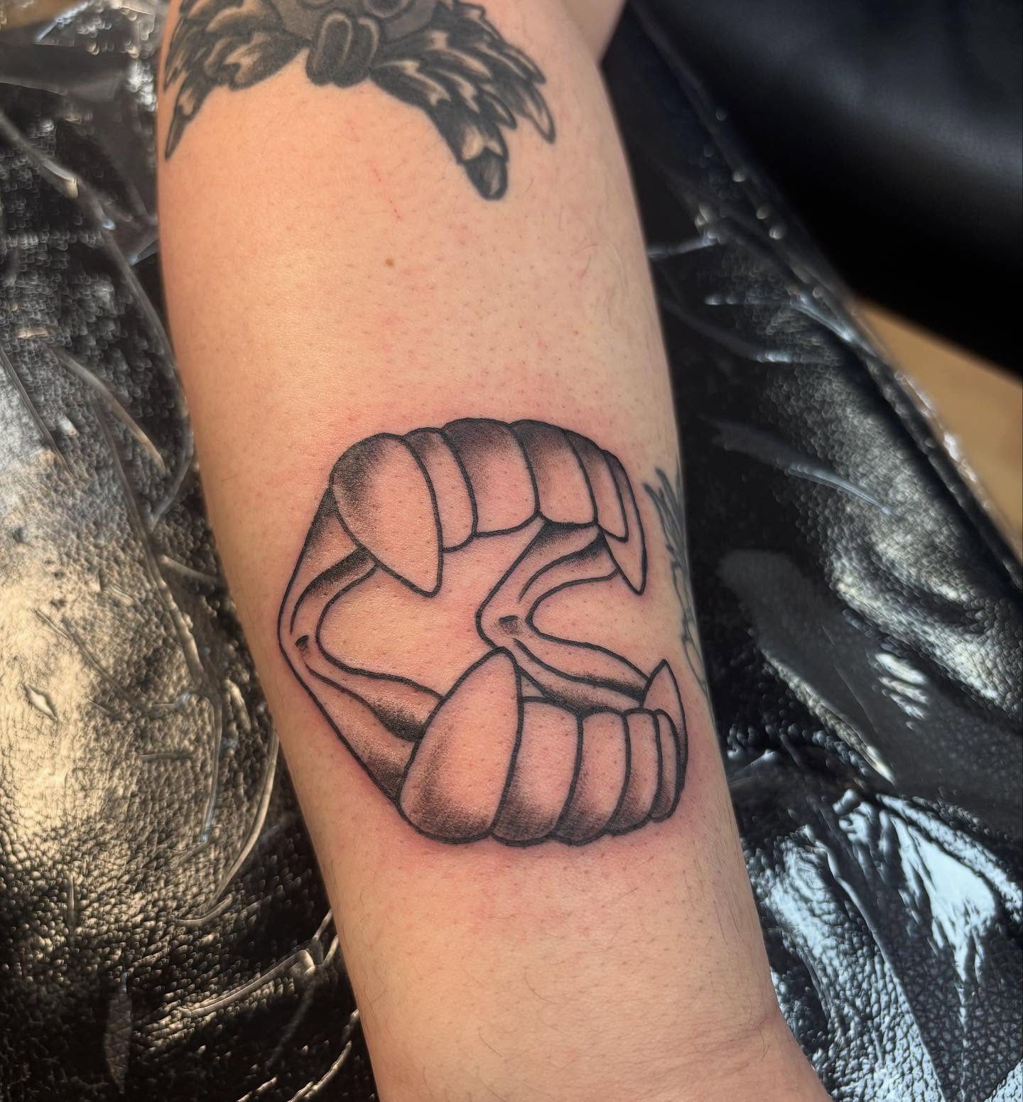 Fist black and grey tattoo on the forearm by Nick Tate