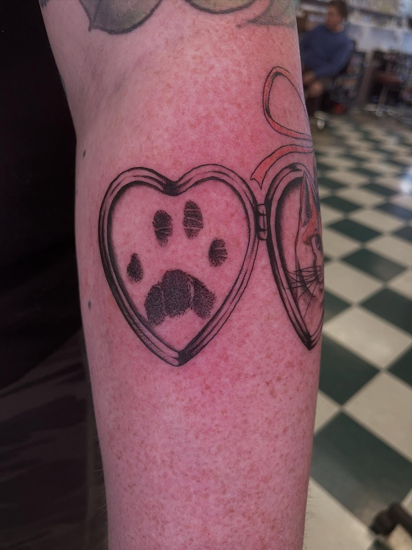 Heart locket with paw print black and grey tattoo on the forearm by Dayton Tattoo Artist, Miamisburg, Ohio