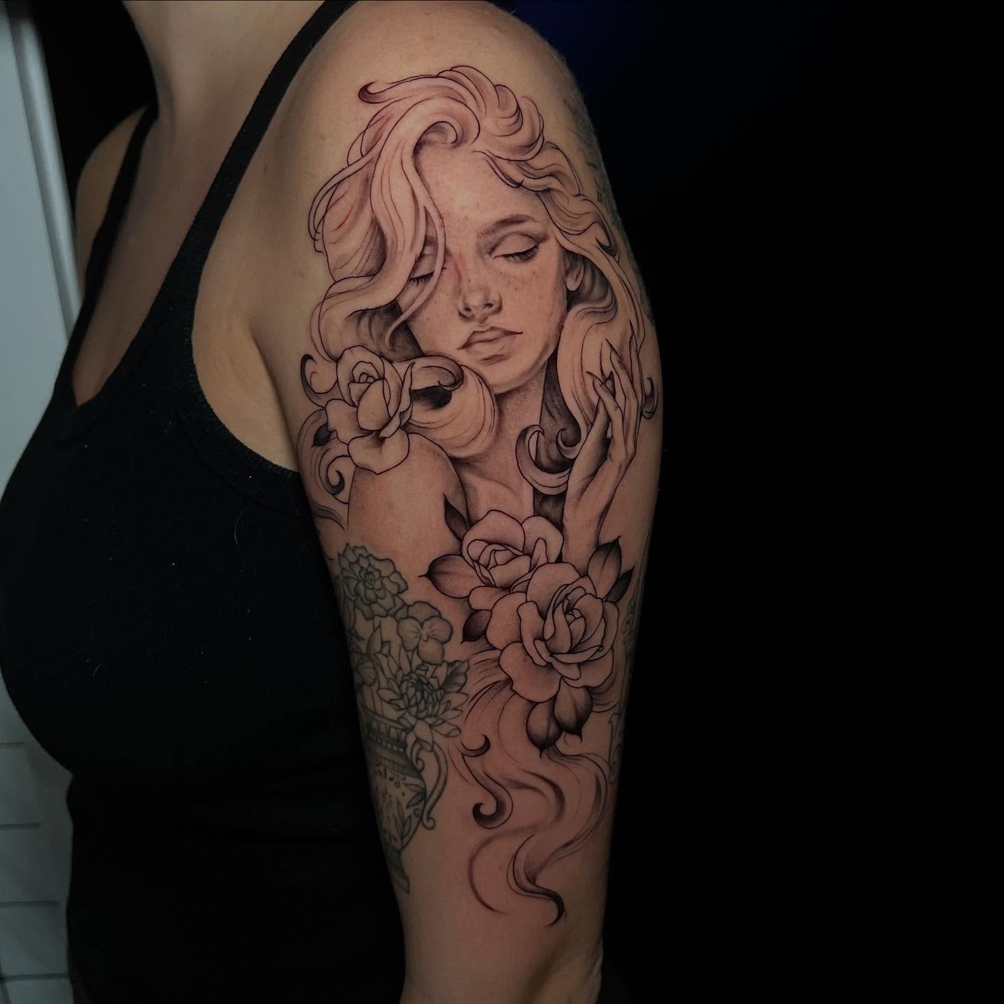 Woman with roses realism tattoo on the upper arm by l y n d s e y r i c k e t t s
