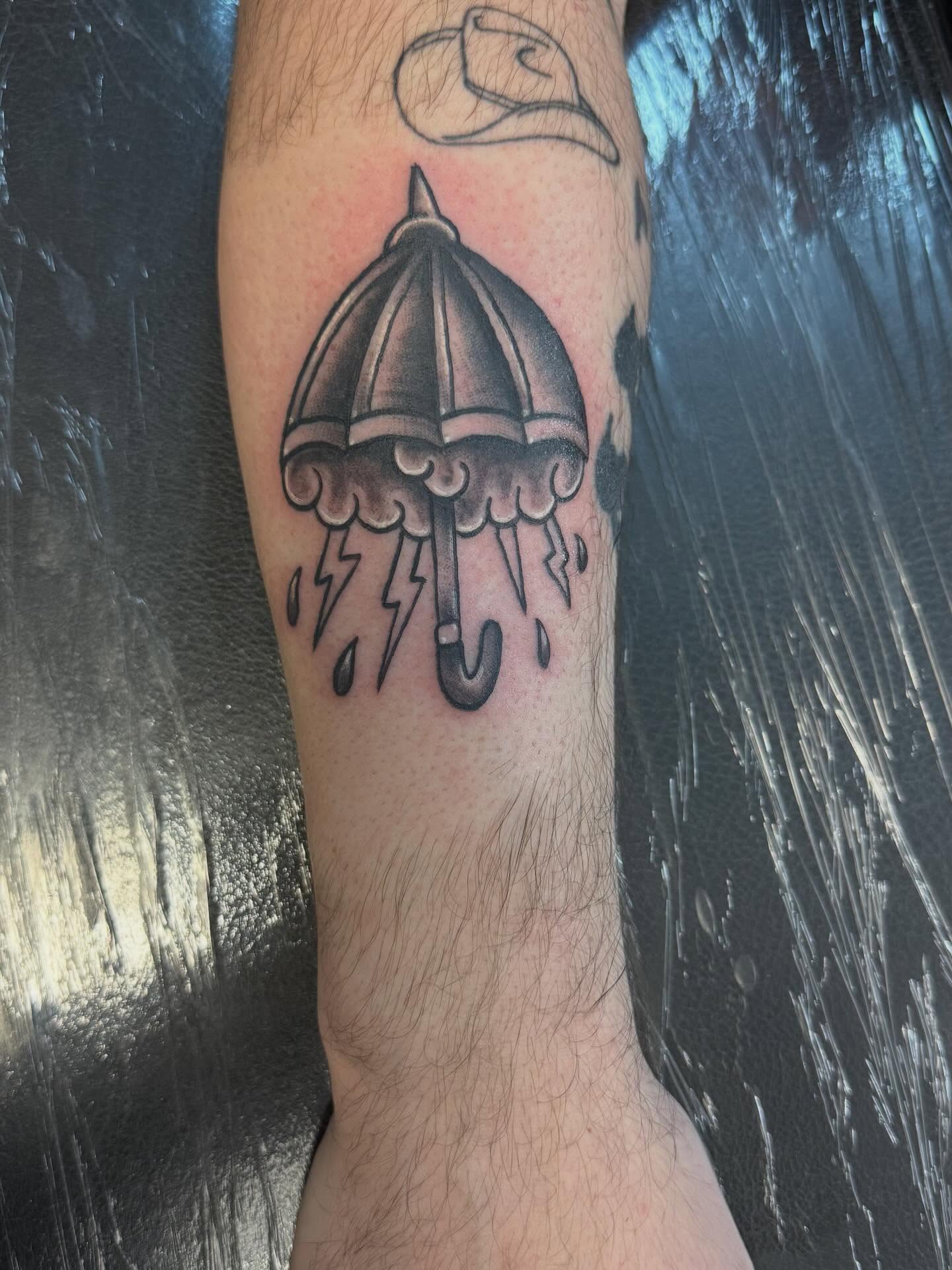 Umbrella black and grey tattoo on the forearm by Daniel Smith
