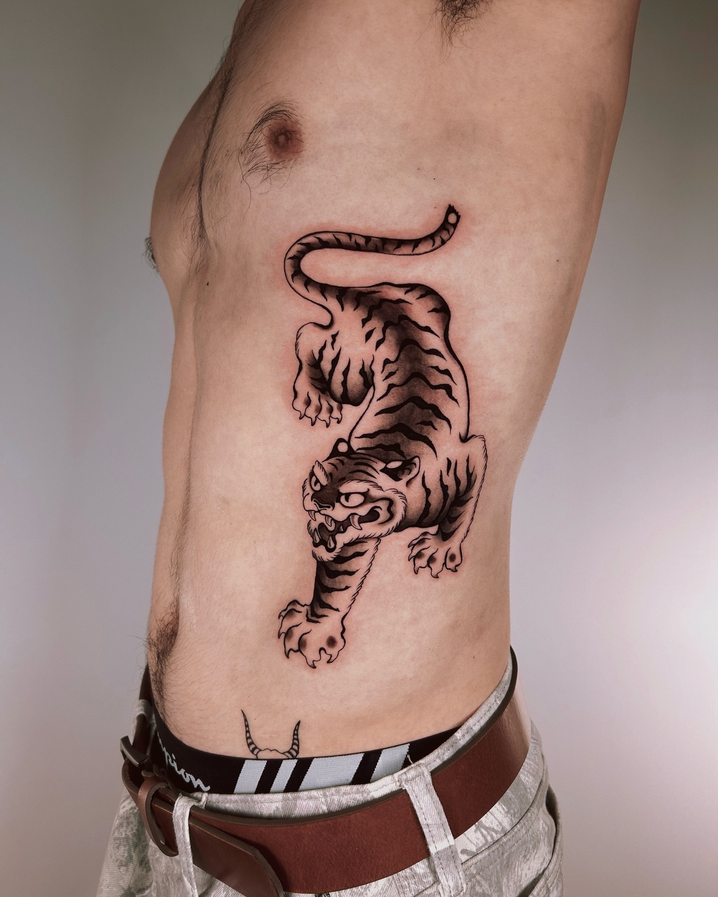 Tiger black and grey tattoo on the ribs by Montana Chambers