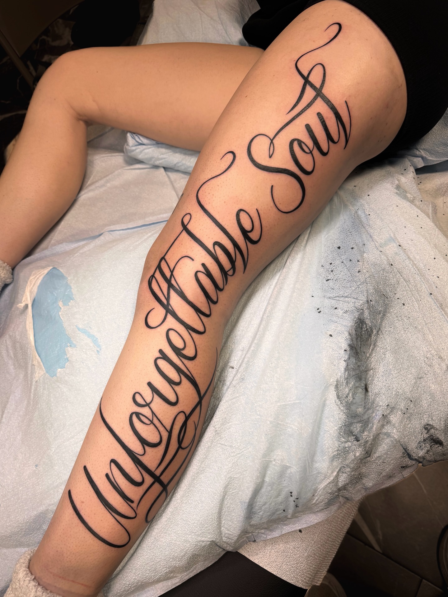Unforgettable Soul lettering script tattoo on the leg by Suda