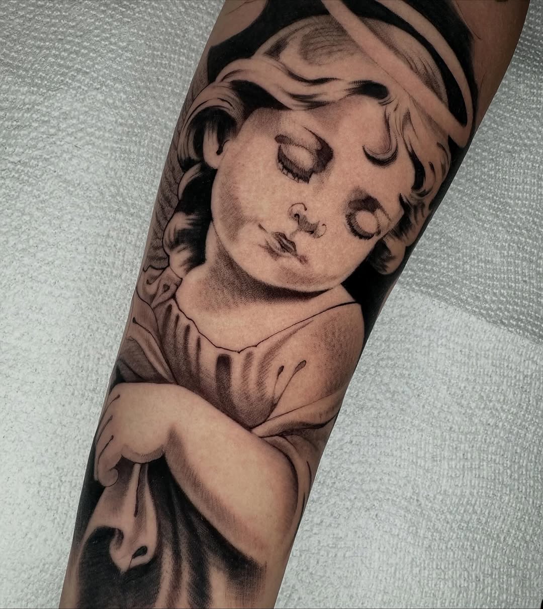 Cherub statue realism tattoo on the forearm by Angelo Buonanno, Las Vegas, Nevada