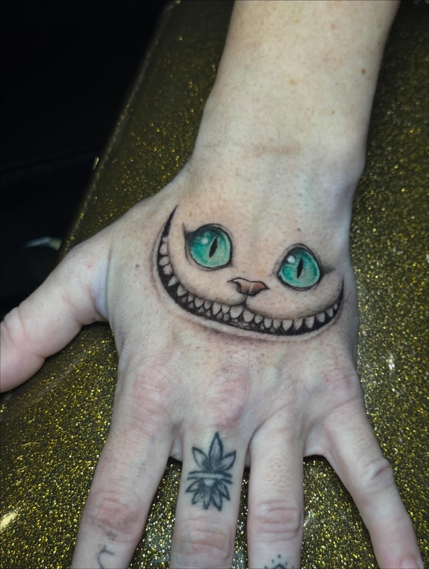 Cheshire cat realism tattoo on the hand by Marquis Neal