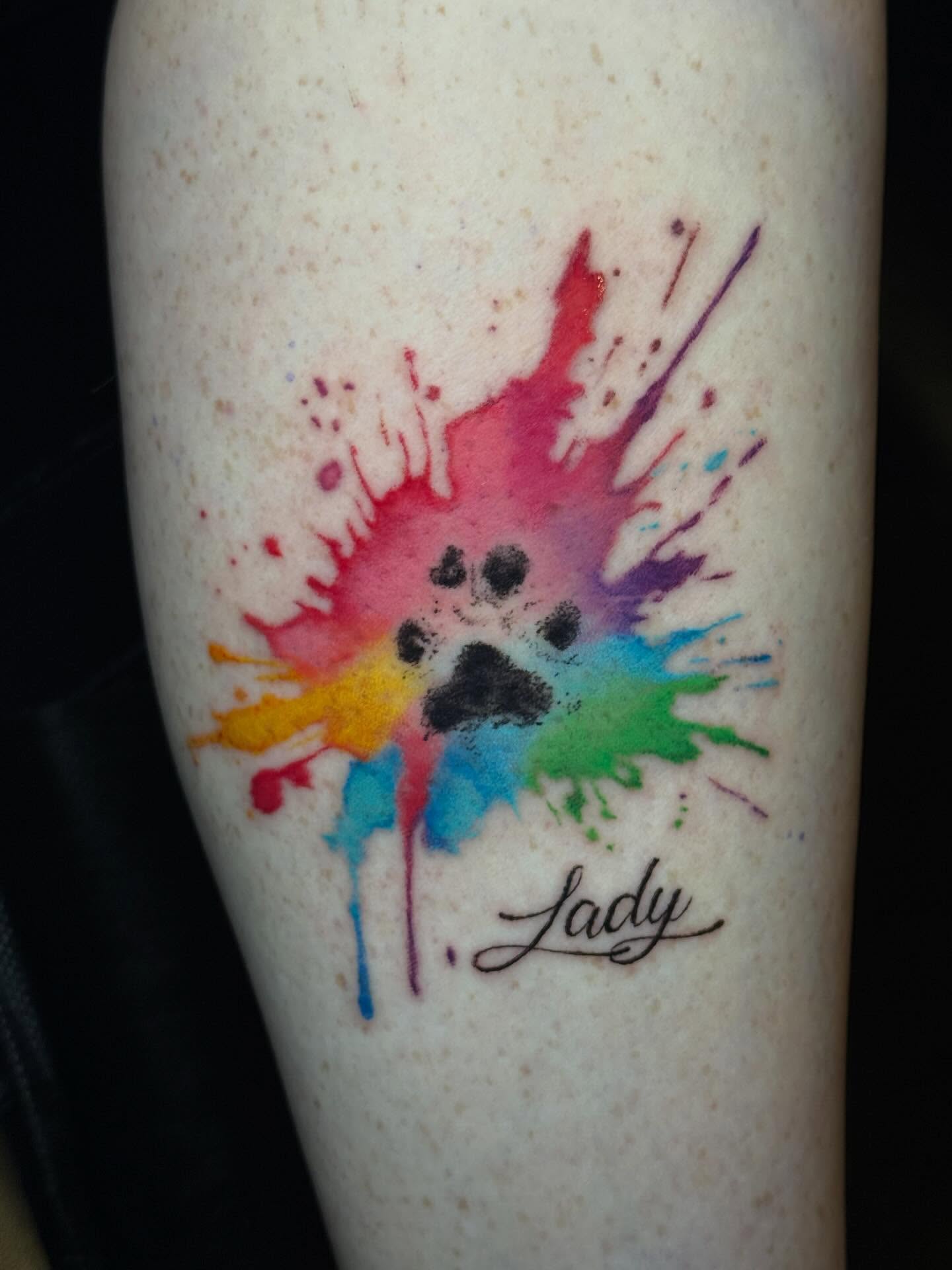 Paw print watercolor tattoo on the forearm by Marquis Neal
