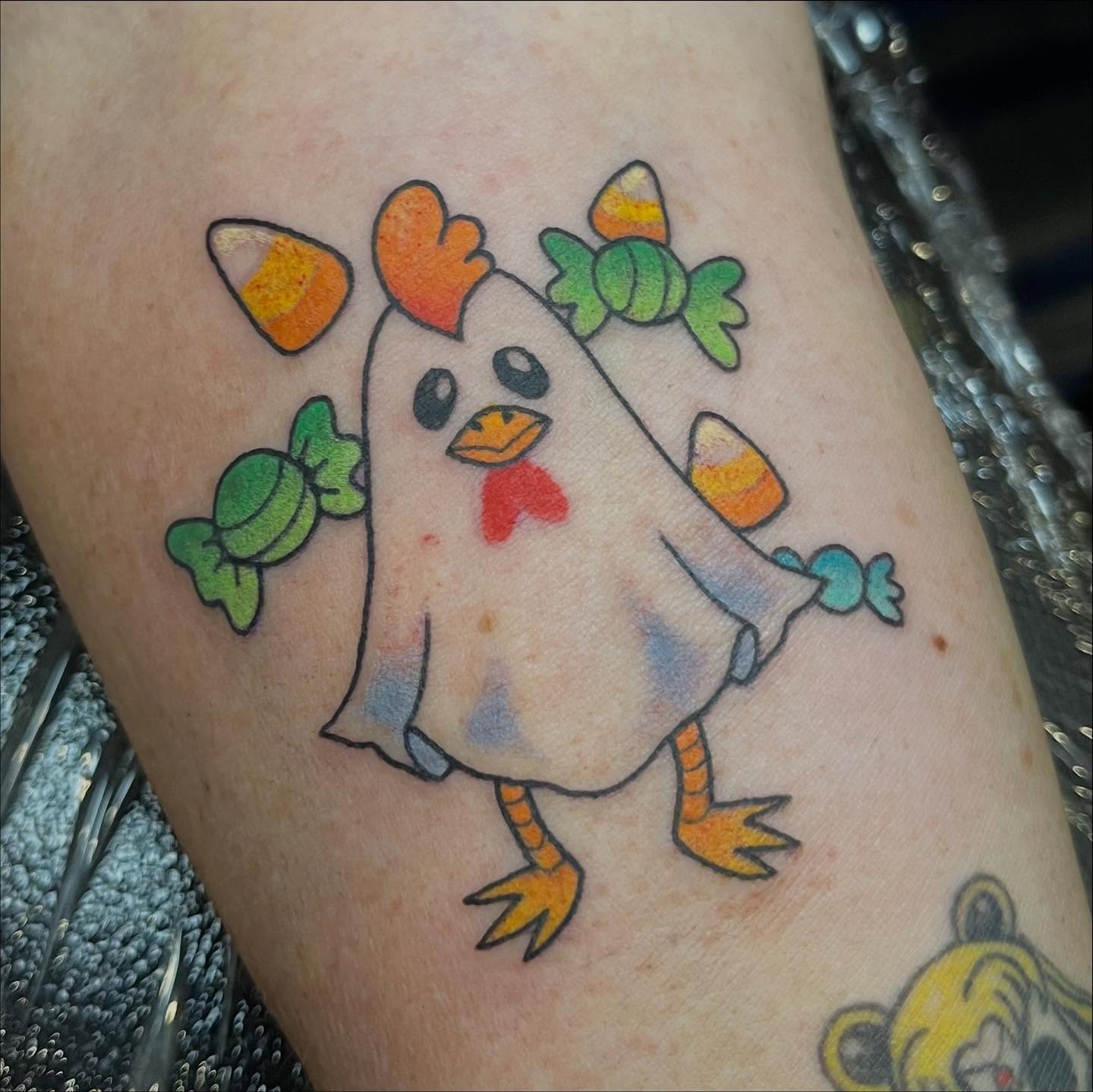 Chicken with candy corn watercolor tattoo on the forearm by 🪴Amanda Lugo🪴 Ocala Tattoo Artist