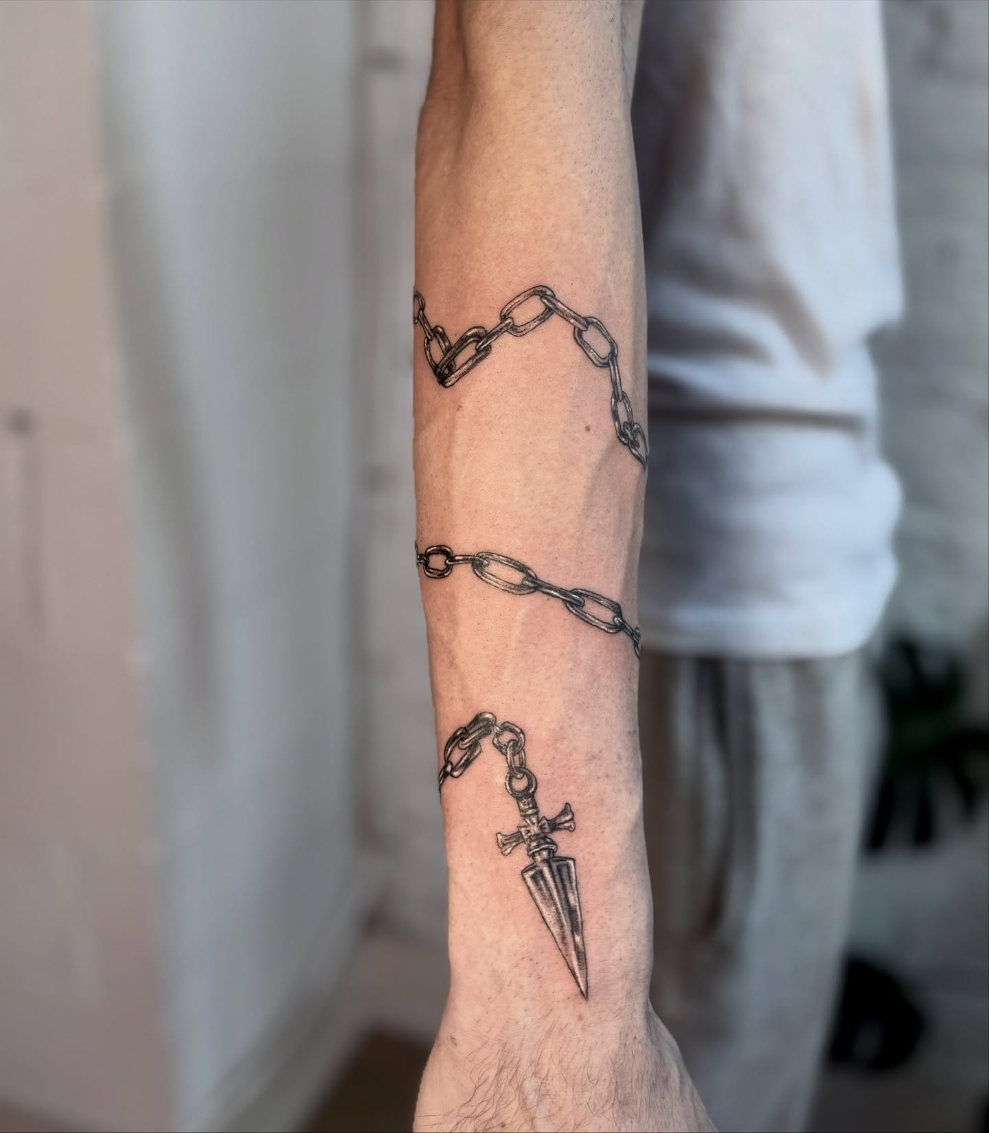 Chains and dagger black and grey tattoo on the forearm by Asia Rene Tattoos👑