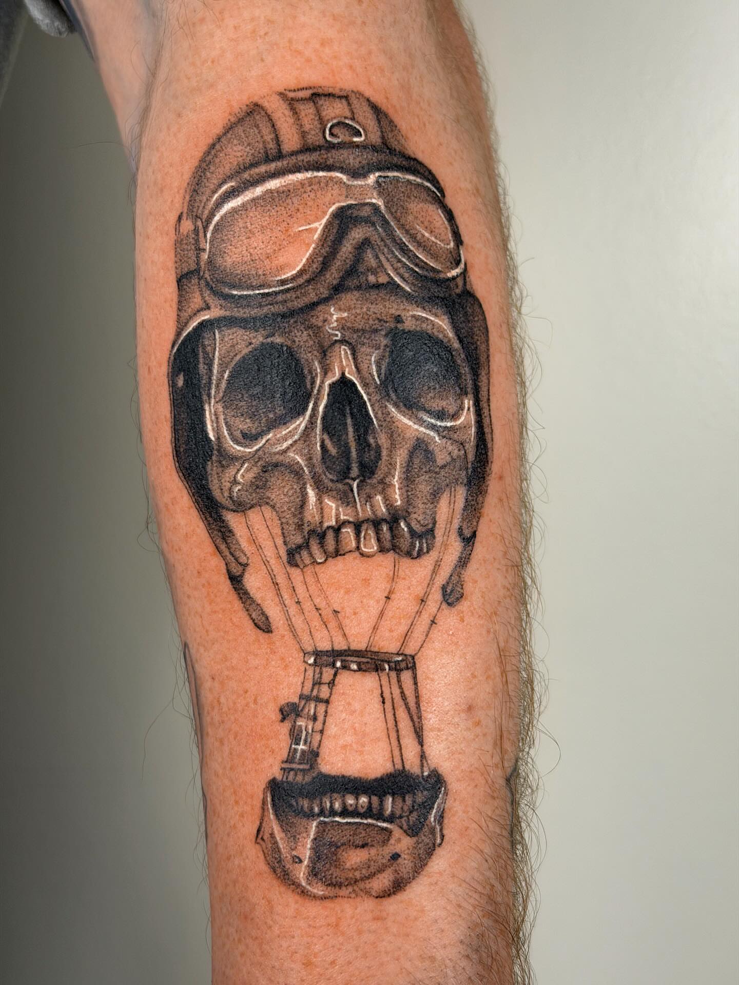 Skull with hot air balloon realism tattoo on the forearm by Nate Weaver