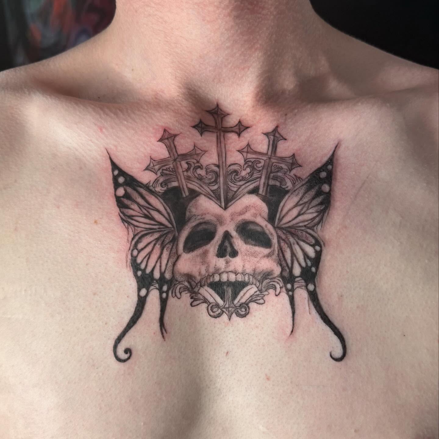 Skull with crown black and grey tattoo on the chest by Nina Rush