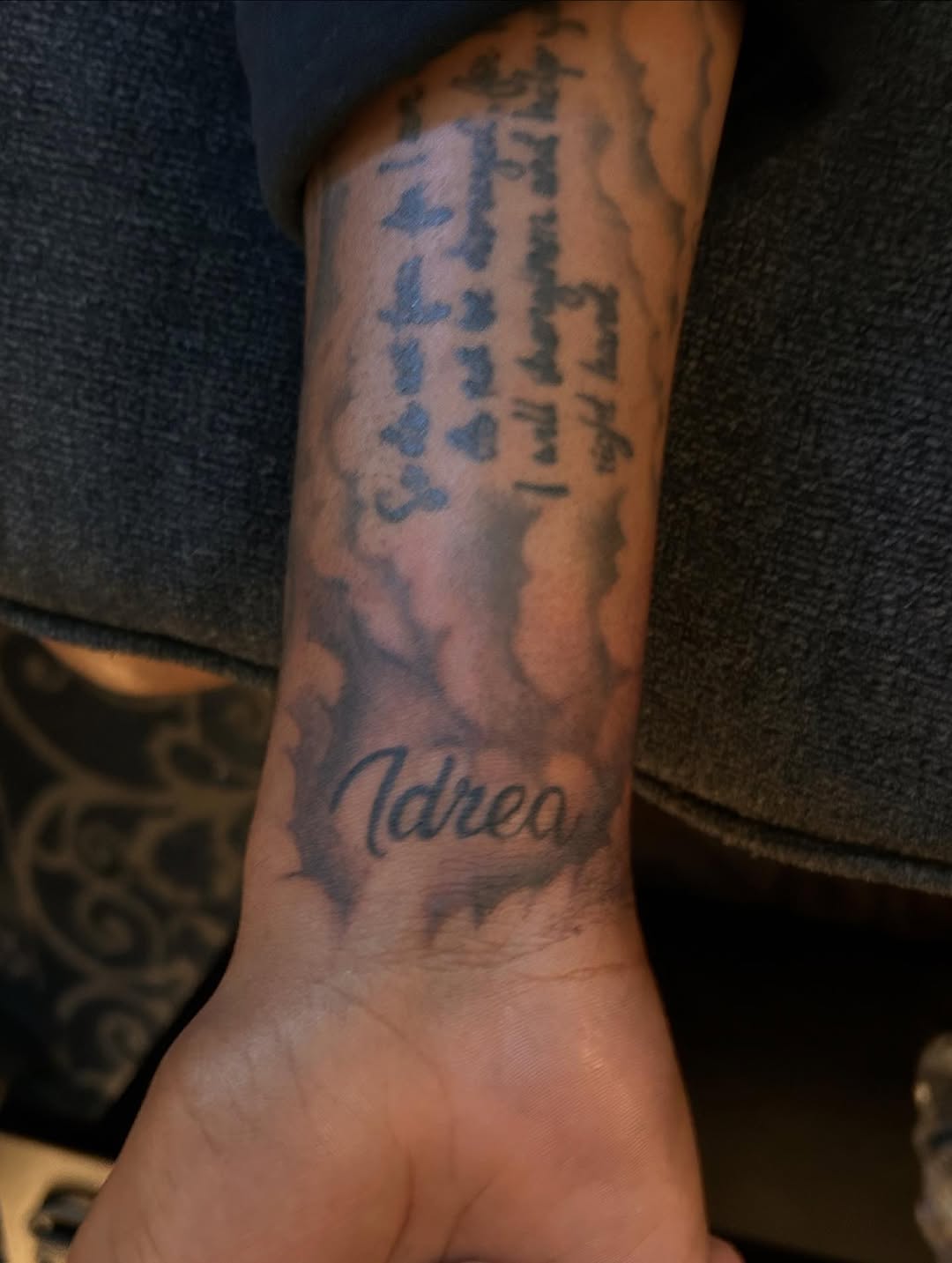 Name and scripture lettering tattoo on the forearm by JE