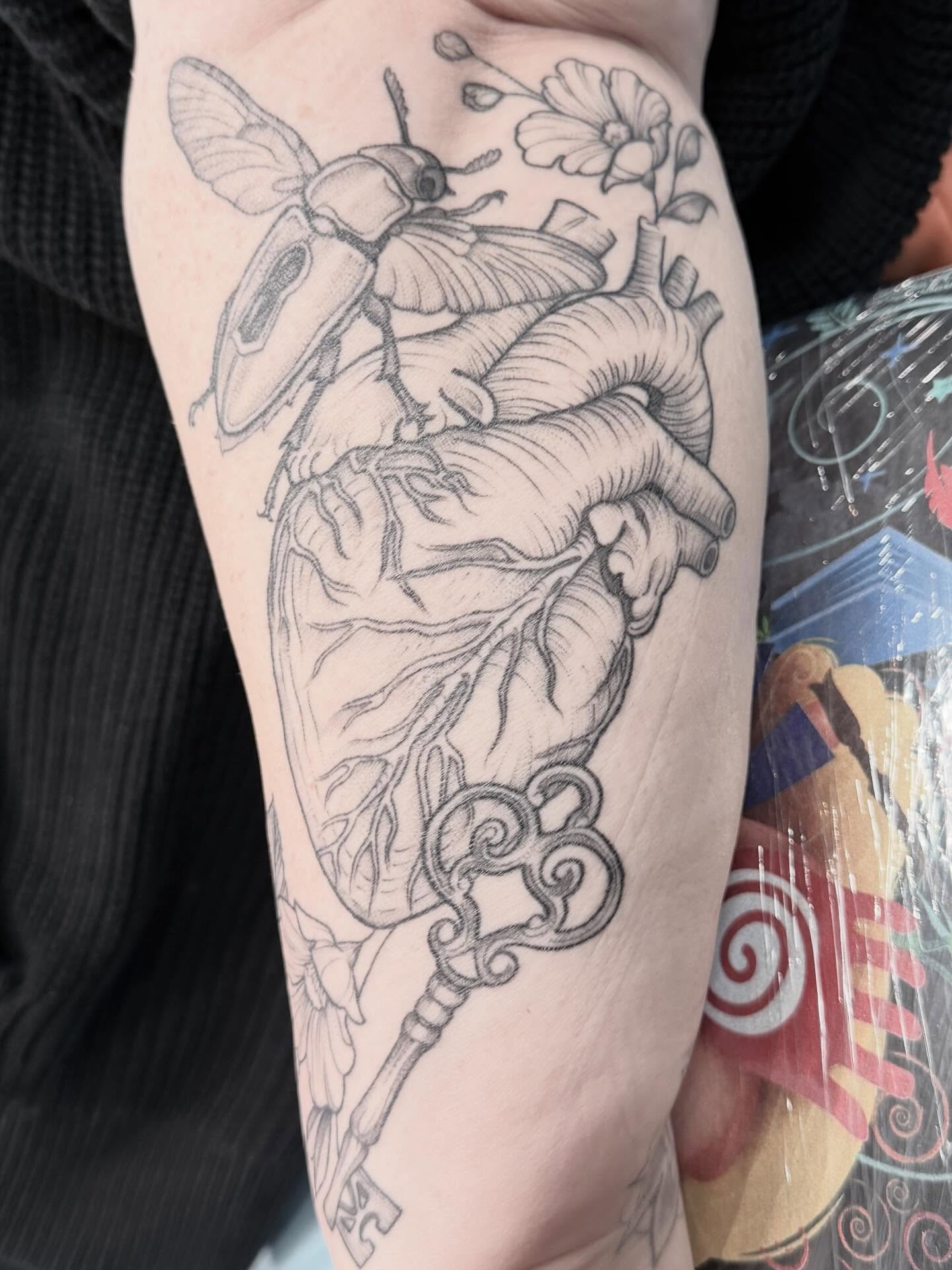 Heart with beetle and key realism tattoo on the forearm by Kirsten Marsden Ballantyne