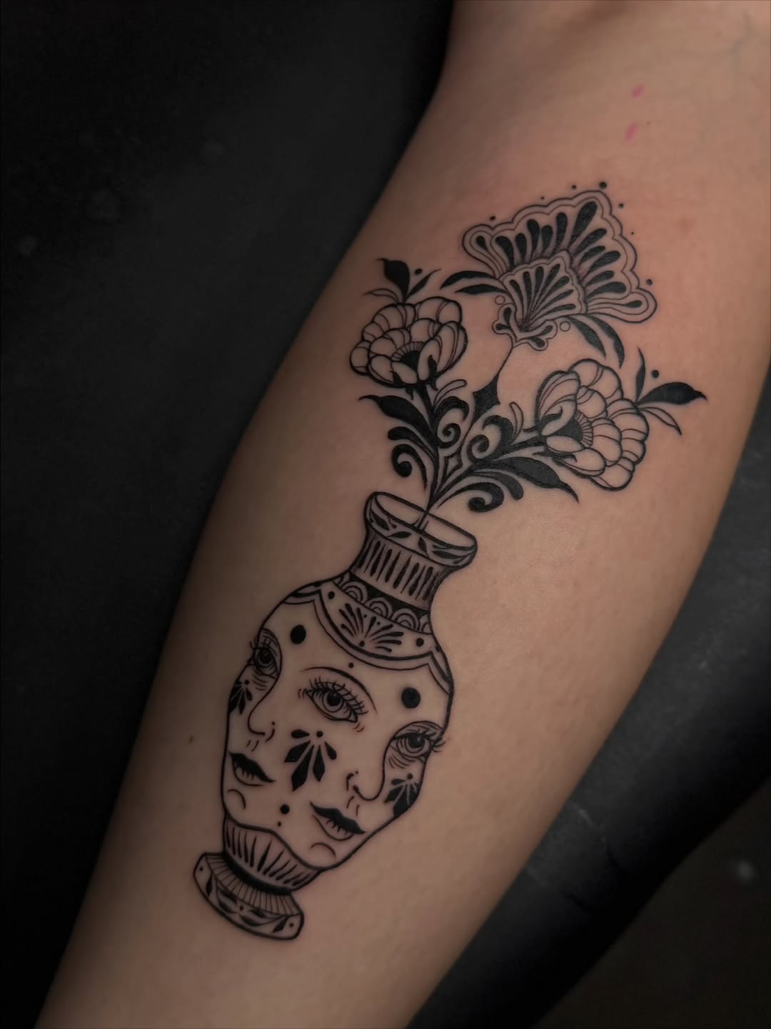 Vase with faces and flowers surrealism tattoo on the forearm by Dee, San Diego, California