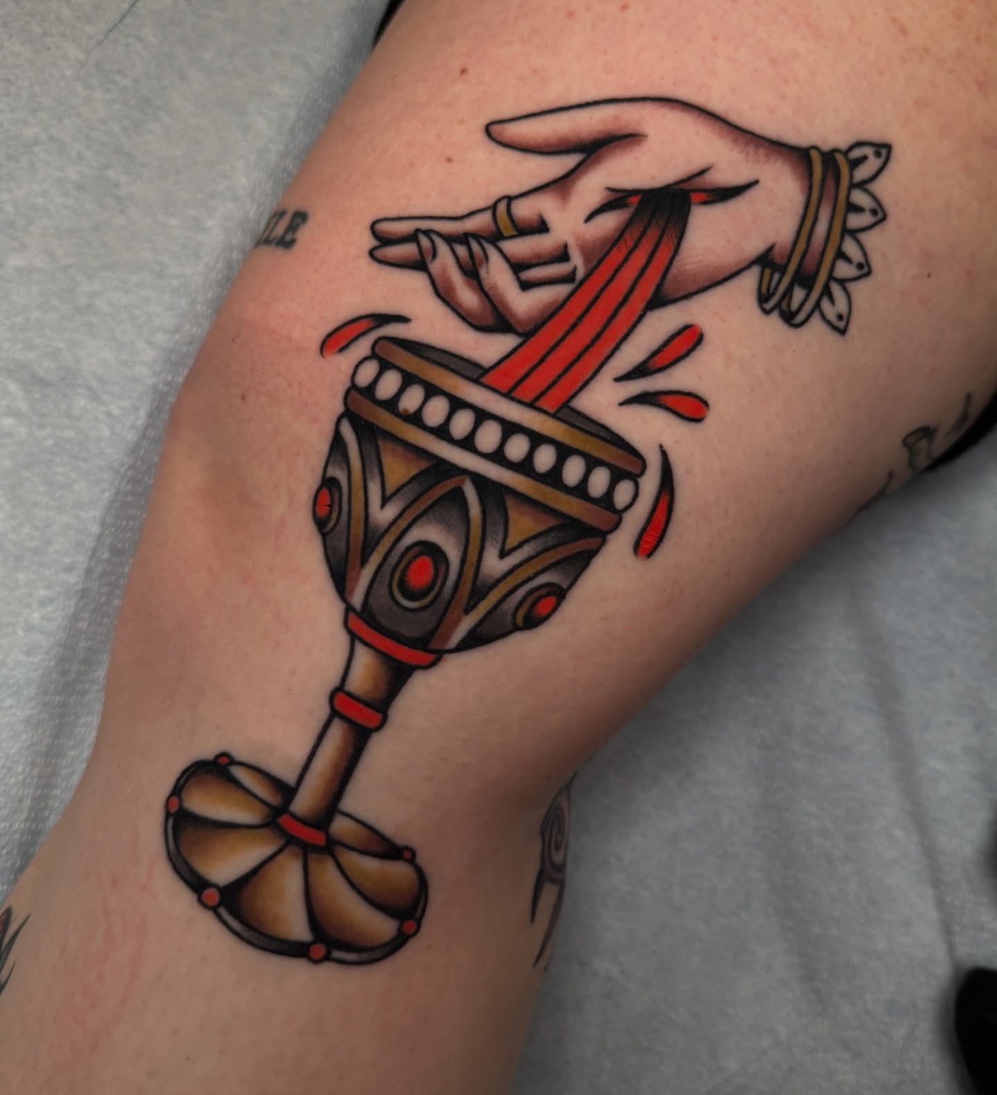 Drum and hand American traditional tattoo on the forearm by kate