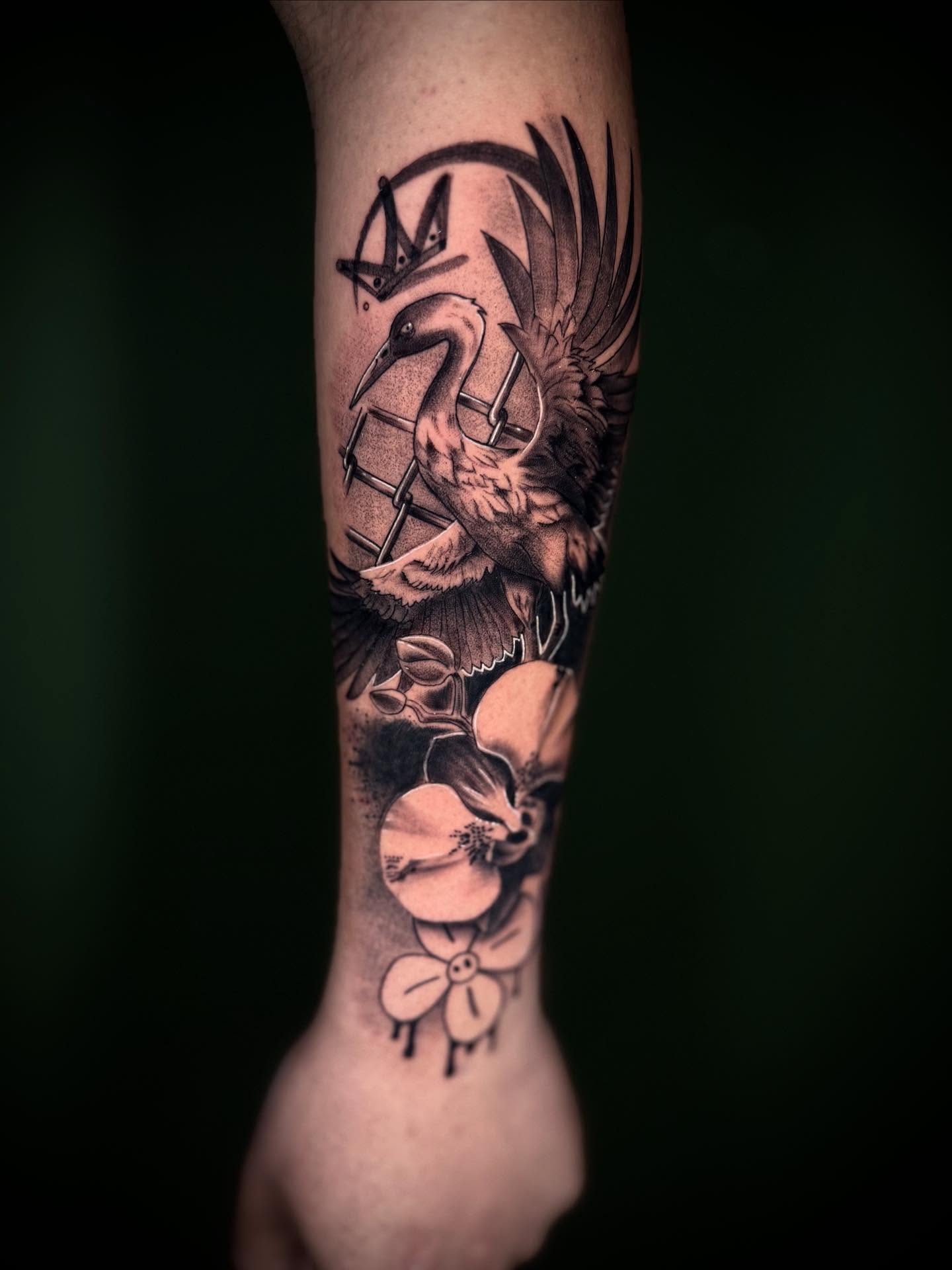 Bird and flowers realism tattoo on the forearm by Terence Taylor