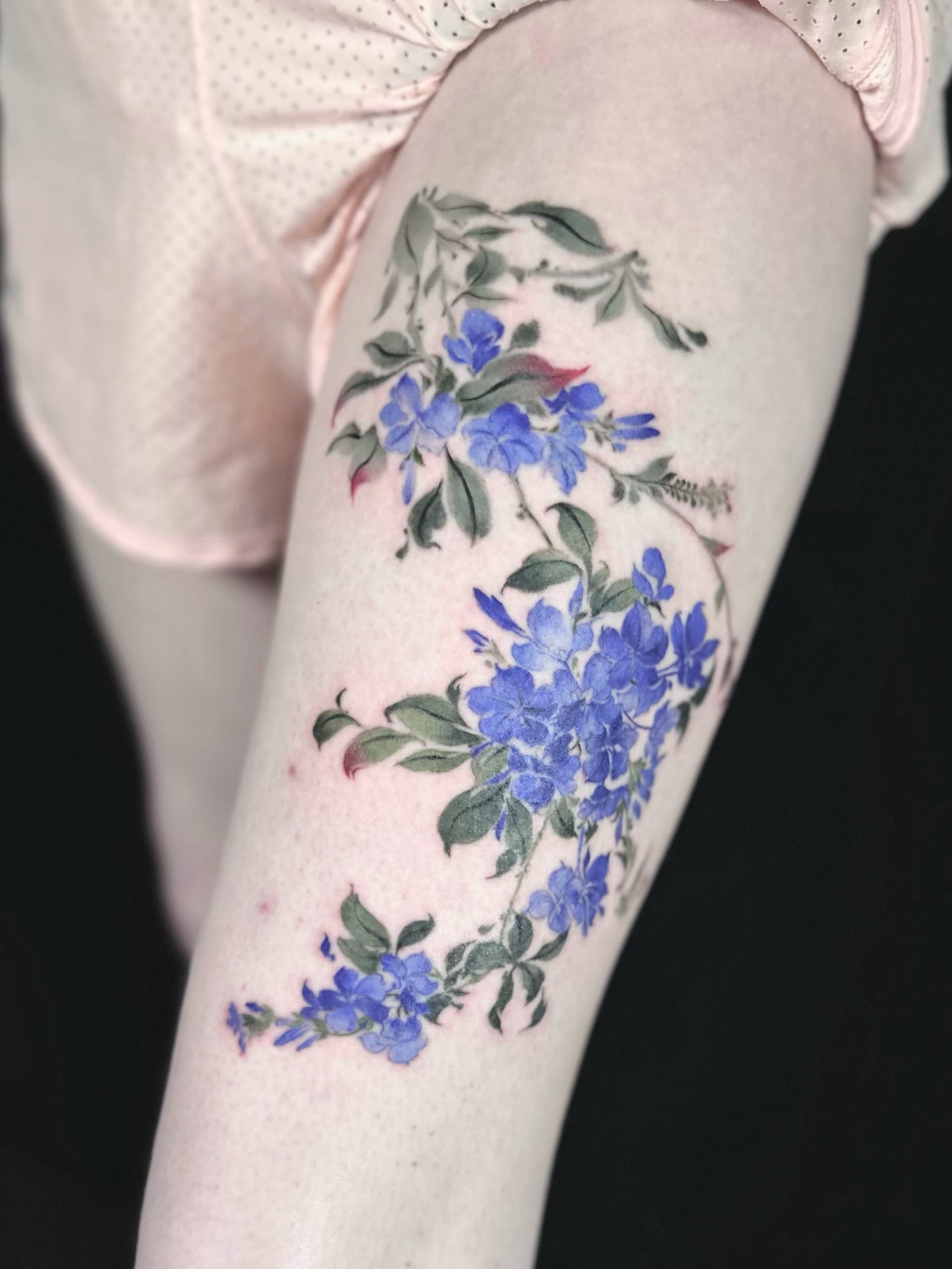 Blue flowers watercolor tattoo on the forearm by Abi