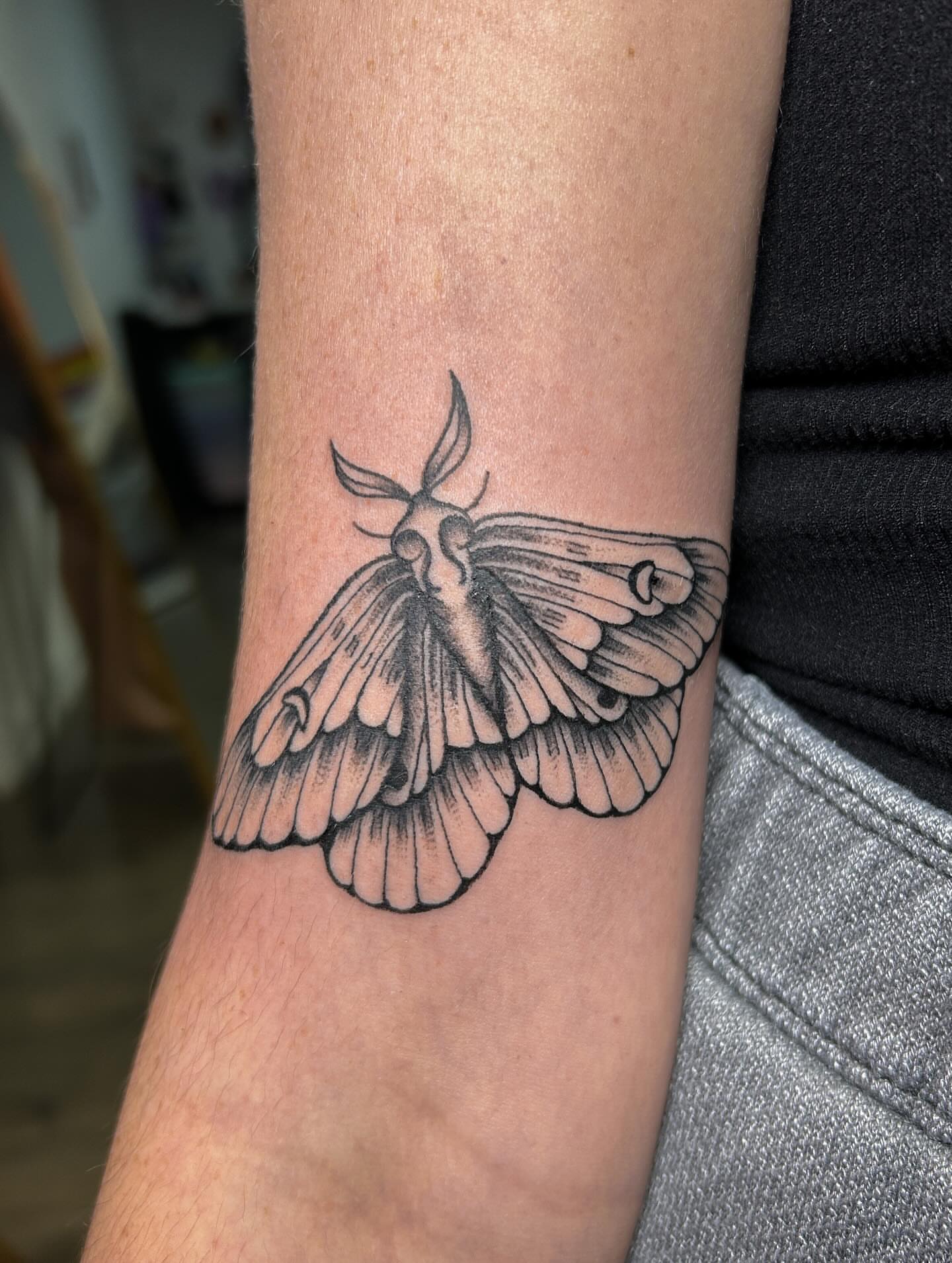 Moth black and grey tattoo on the forearm by Janelle McCarthy