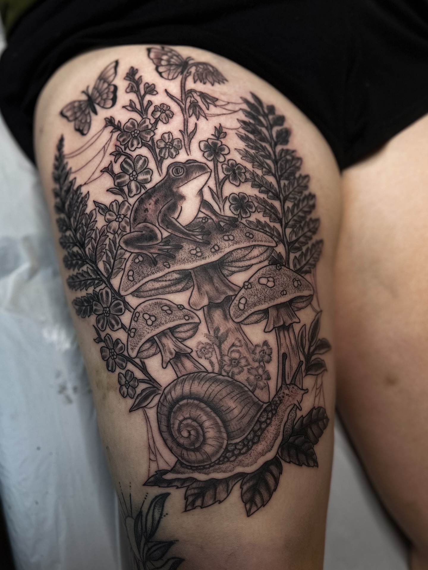 Frogs, mushrooms, snail, flowers realism tattoo on the thigh by แดแด ๐ฎ๐ท ๐ฆ๐ซ