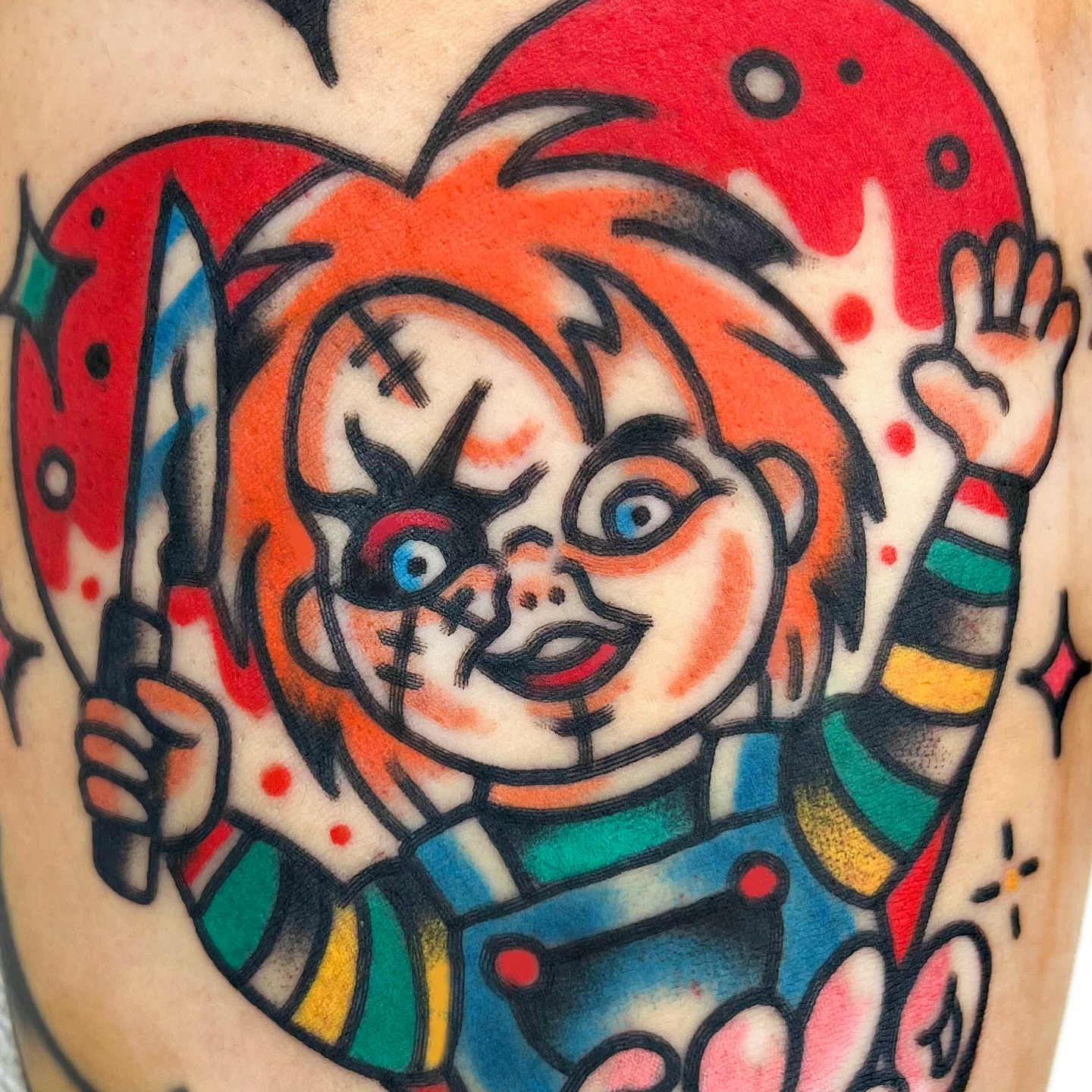 Chucky doll American traditional tattoo on the upper arm by 올드스쿨타투 레드립