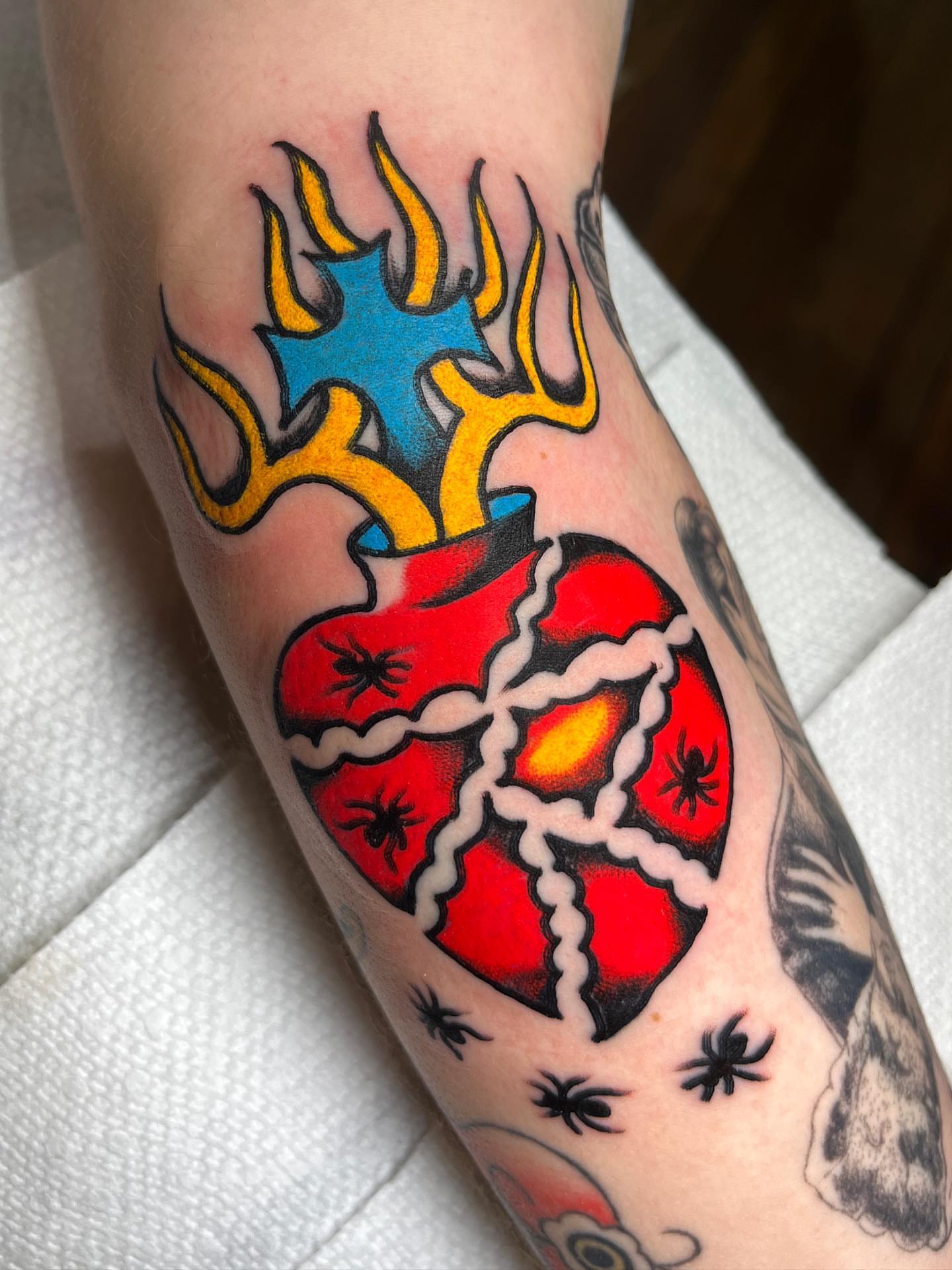 Broken heart with flames American traditional tattoo on the forearm by Charlie Ostrom, Durham, North Carolina