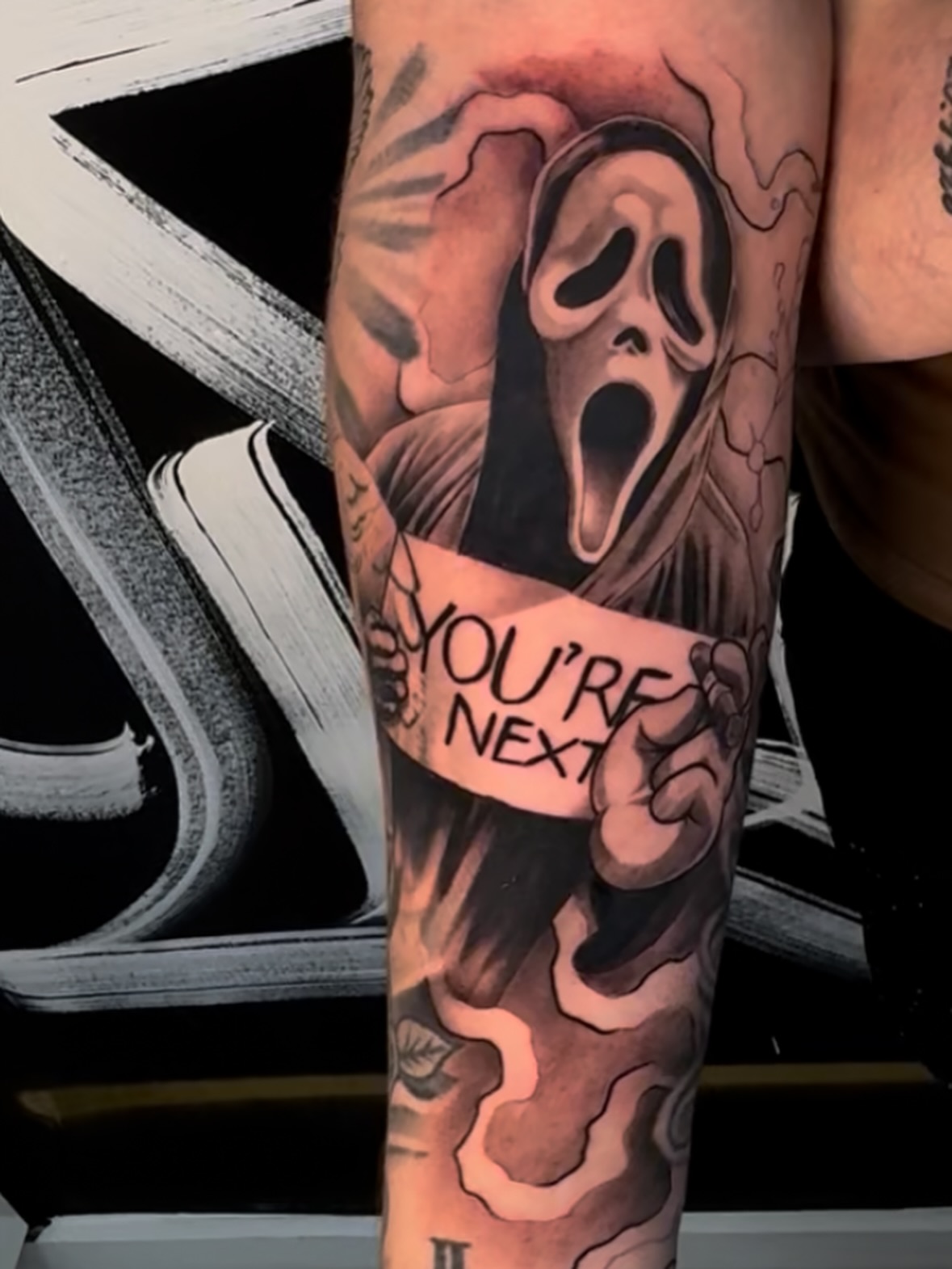 Ghostface black and grey tattoo on the forearm by Lemaih Gonzalez