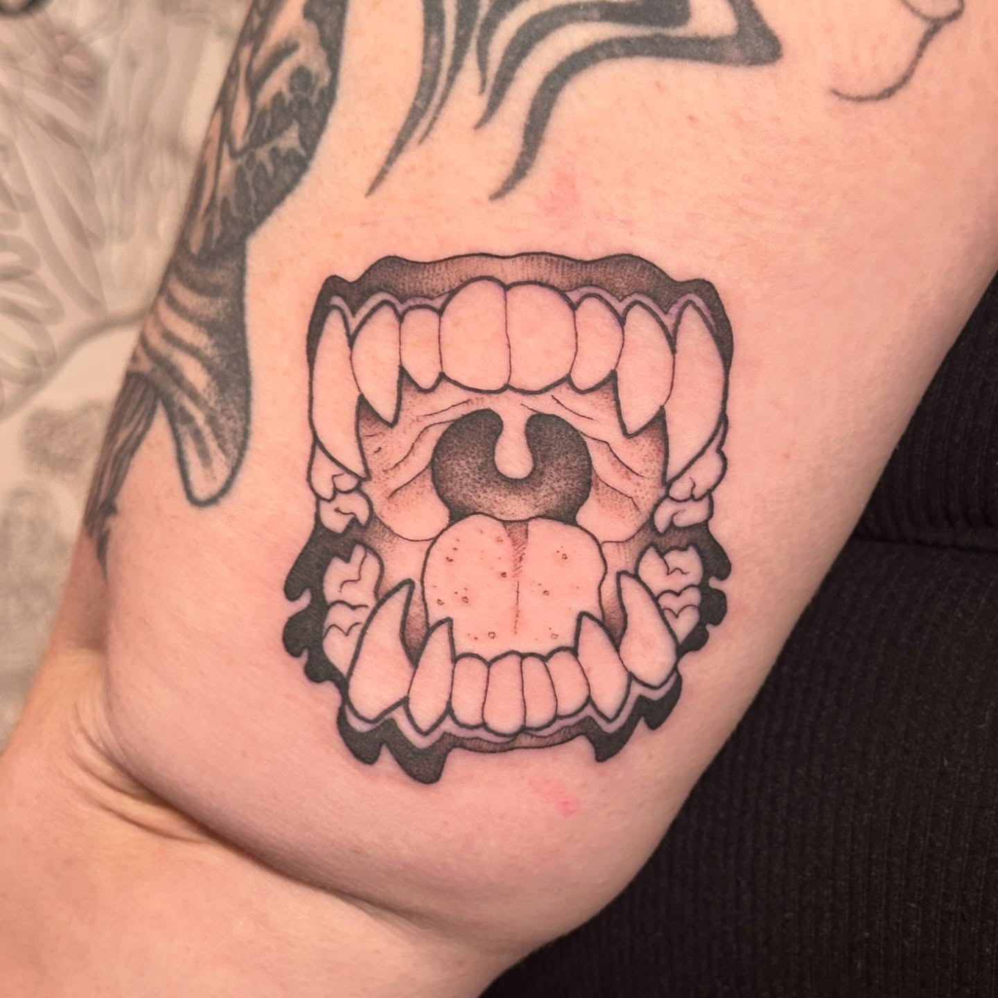 Fangs and tongue black and grey tattoo on the forearm by TATTOOLIZARD (James)